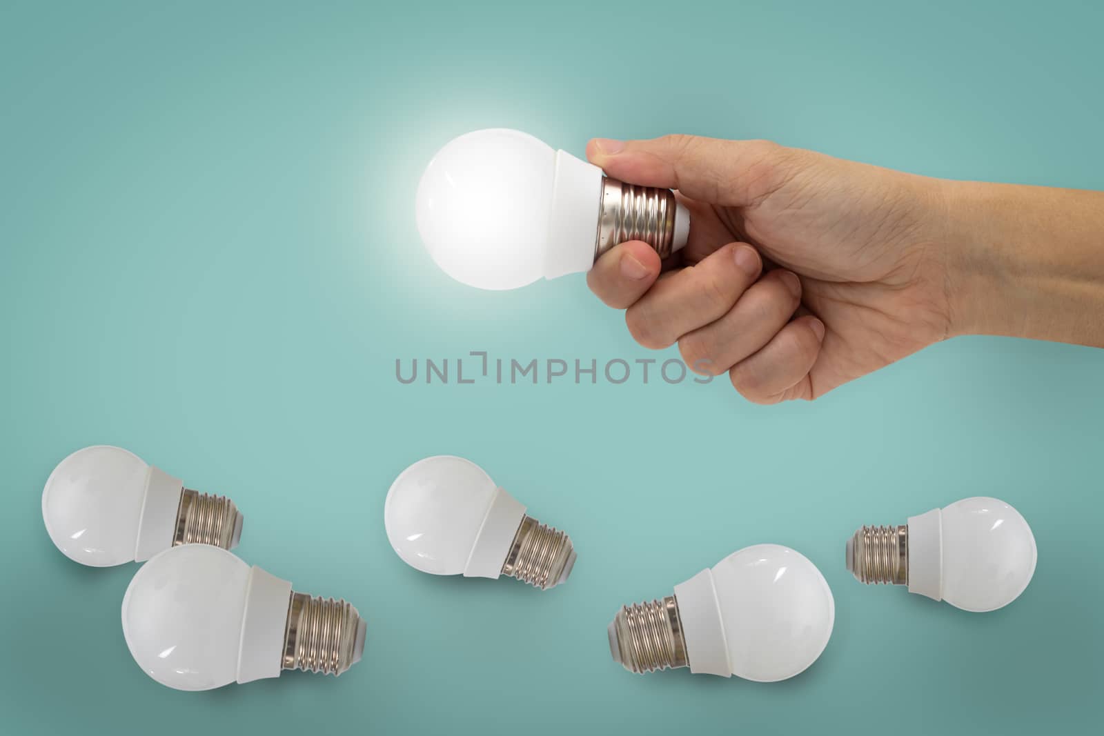 Hand holding illuminated light bulb, idea, inspiration concept.