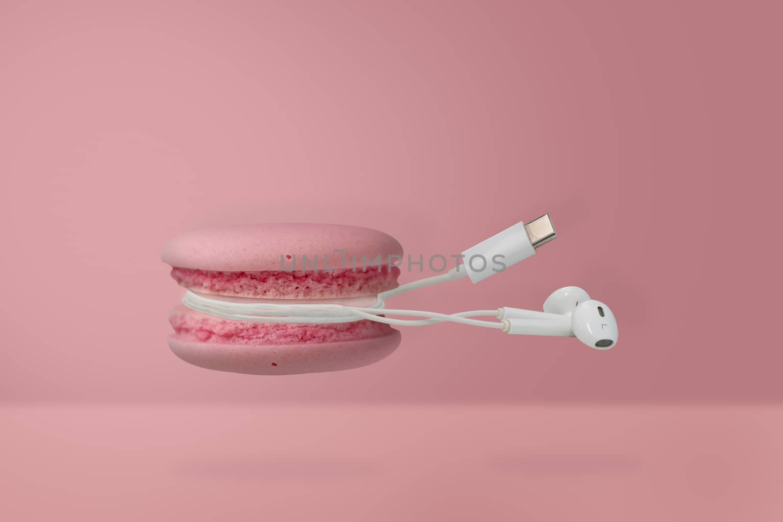 Contemporary art-macaroon and earphone on pink background with copy space, Minimal style.