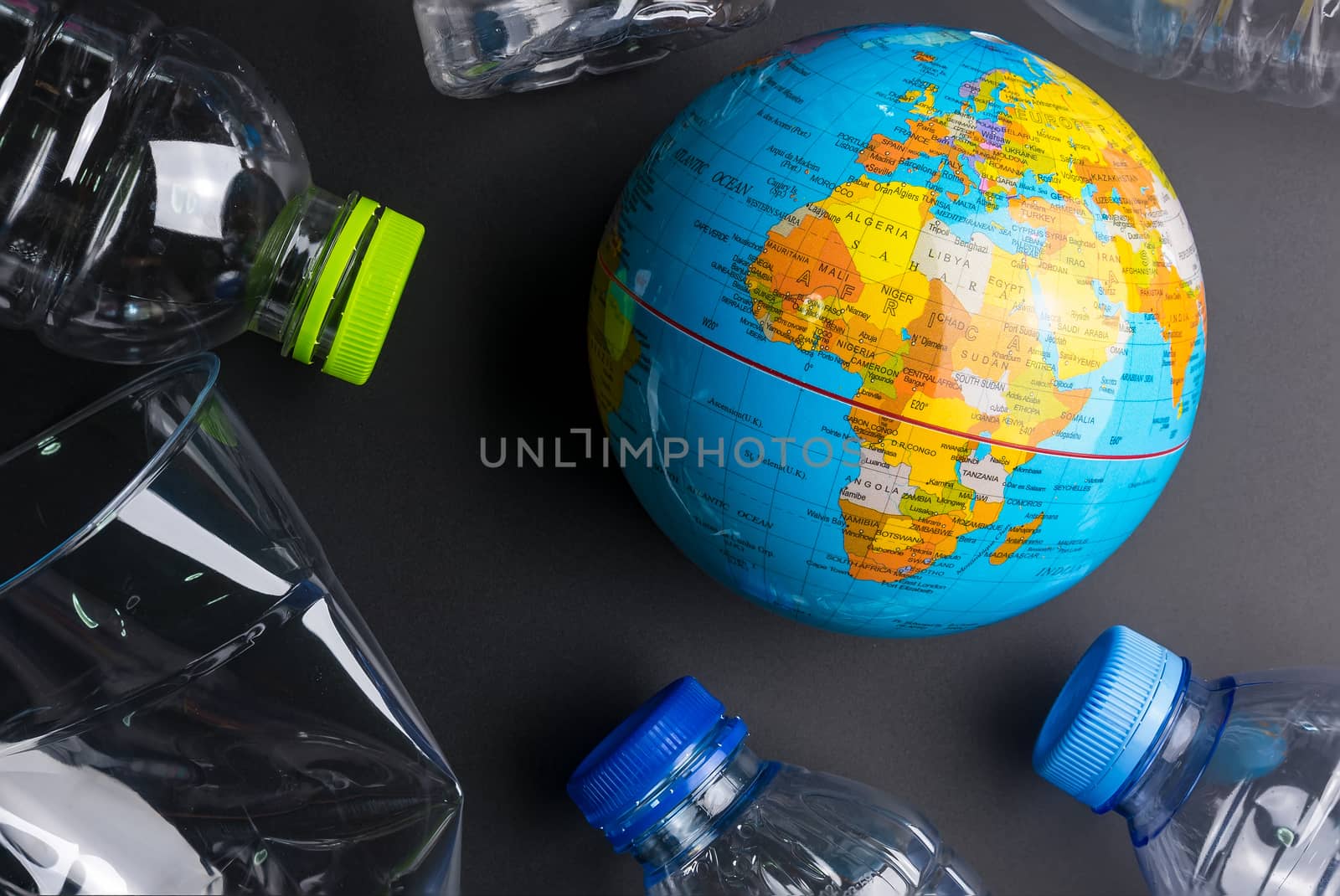 Earth world globe and plastic bottle waste on the black backgrou by Bubbers