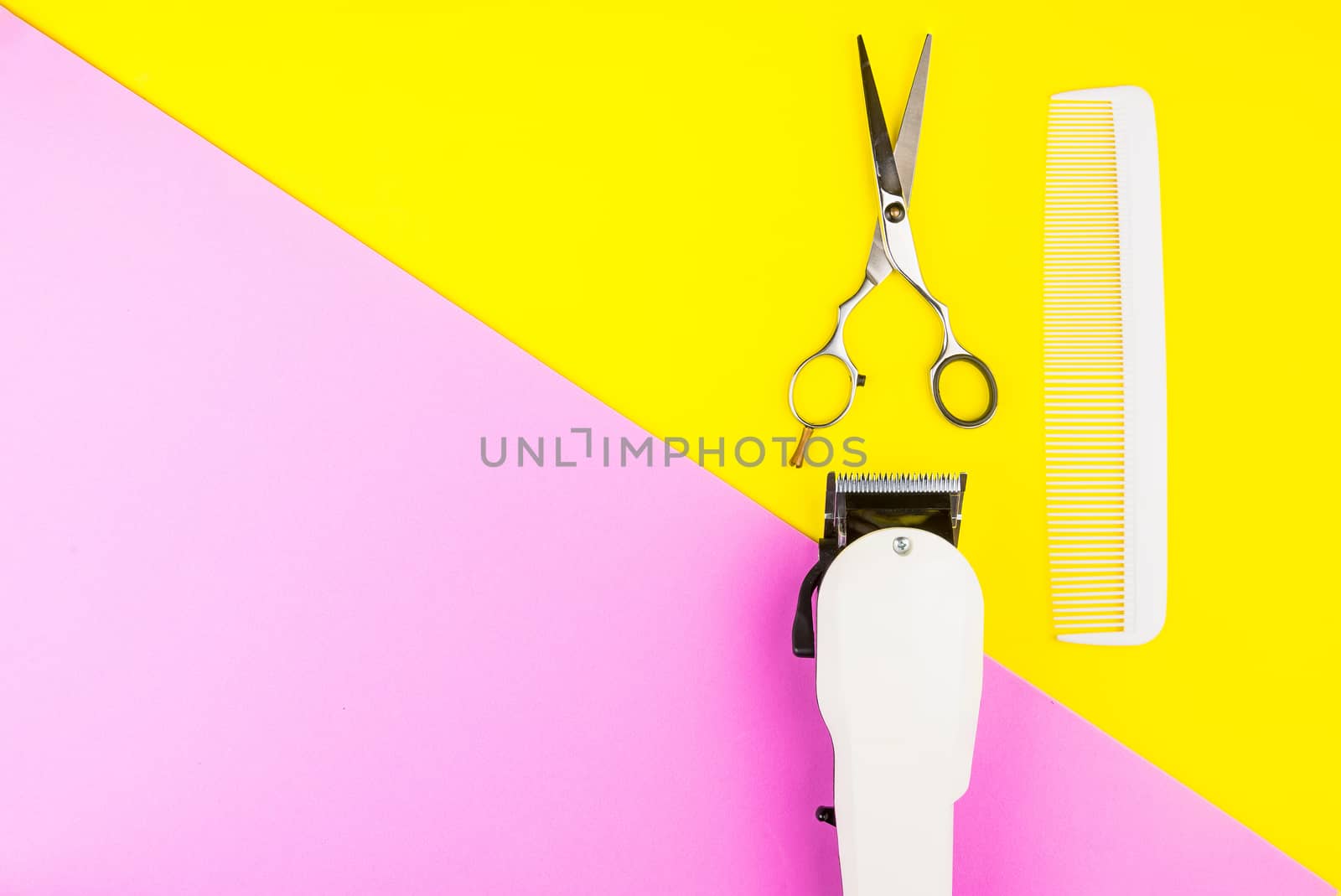 Stylish Professional Barber Scissors and White electric clippers on yellow and pink background. Hairdresser salon concept, Hairdressing Set. Haircut accessories. Copy space image, flat lay