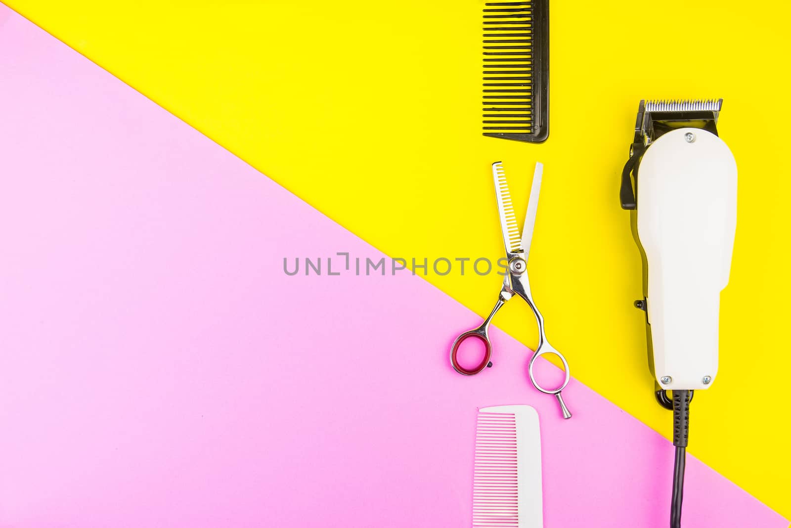 Stylish Professional Barber Scissors and White electric clippers on yellow and pink background. Hairdresser salon concept, Hairdressing Set. Haircut accessories. Copy space image, flat lay