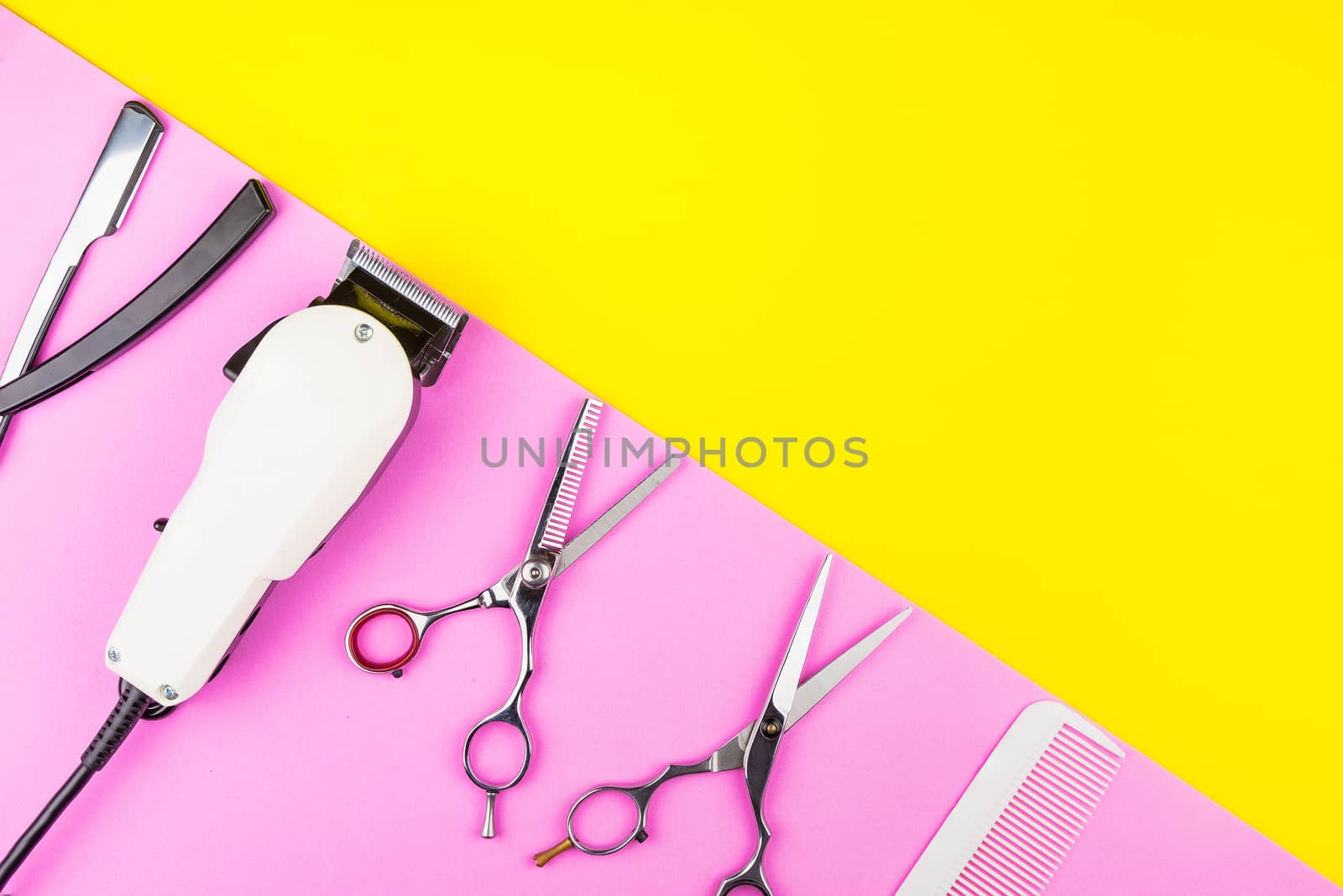 Stylish Professional Barber Scissors and White electric clippers on yellow and pink background. Hairdresser salon concept, Hairdressing Set. Haircut accessories. Copy space image, flat lay