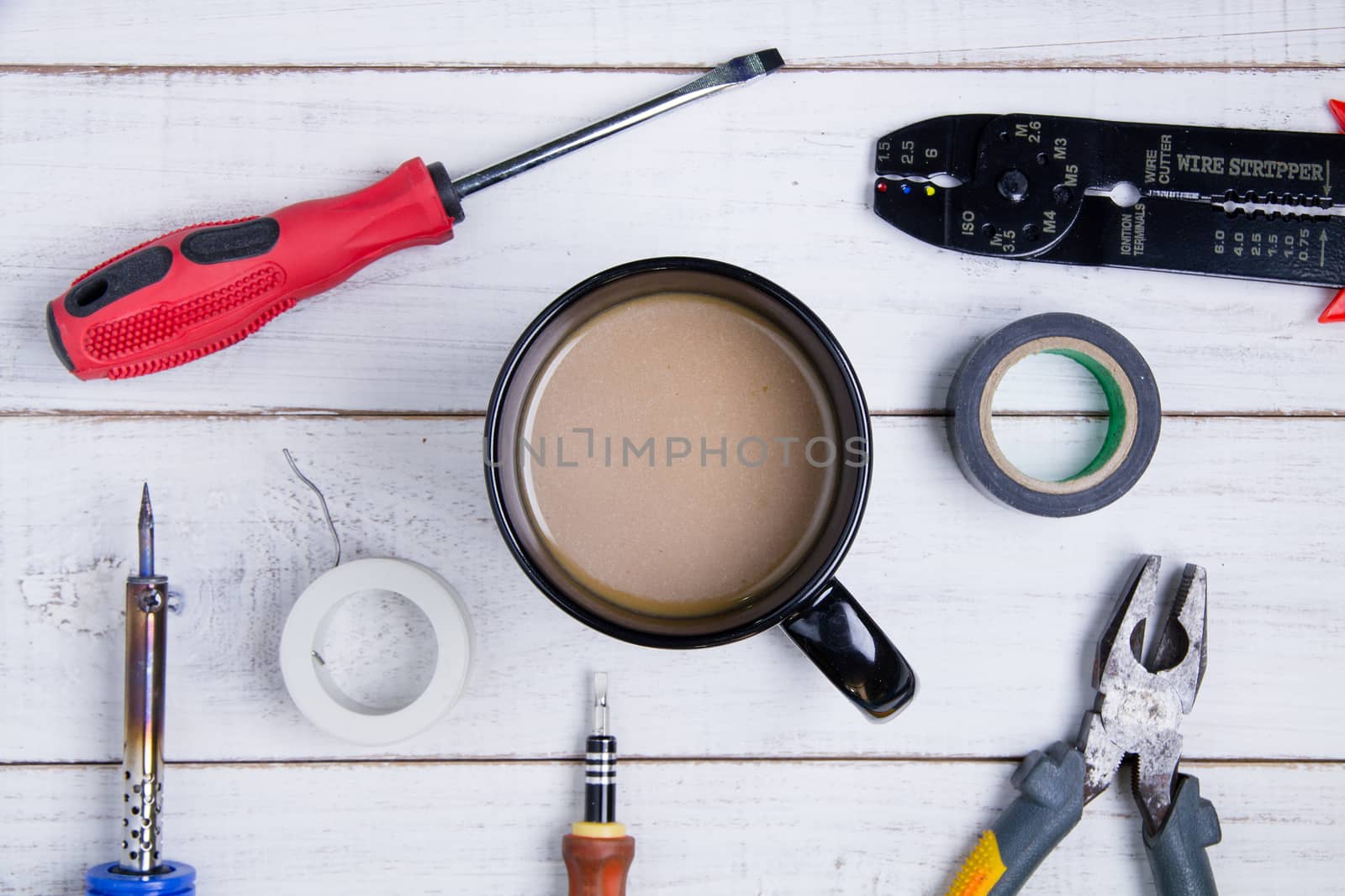 Coffee cup and equipment repair on the white wooden background.