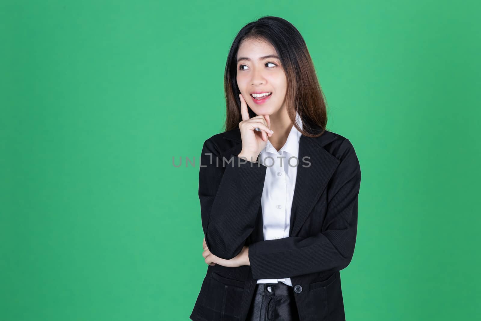 Portrait of attractive young Asian business woman having idea posing on green isolated background.