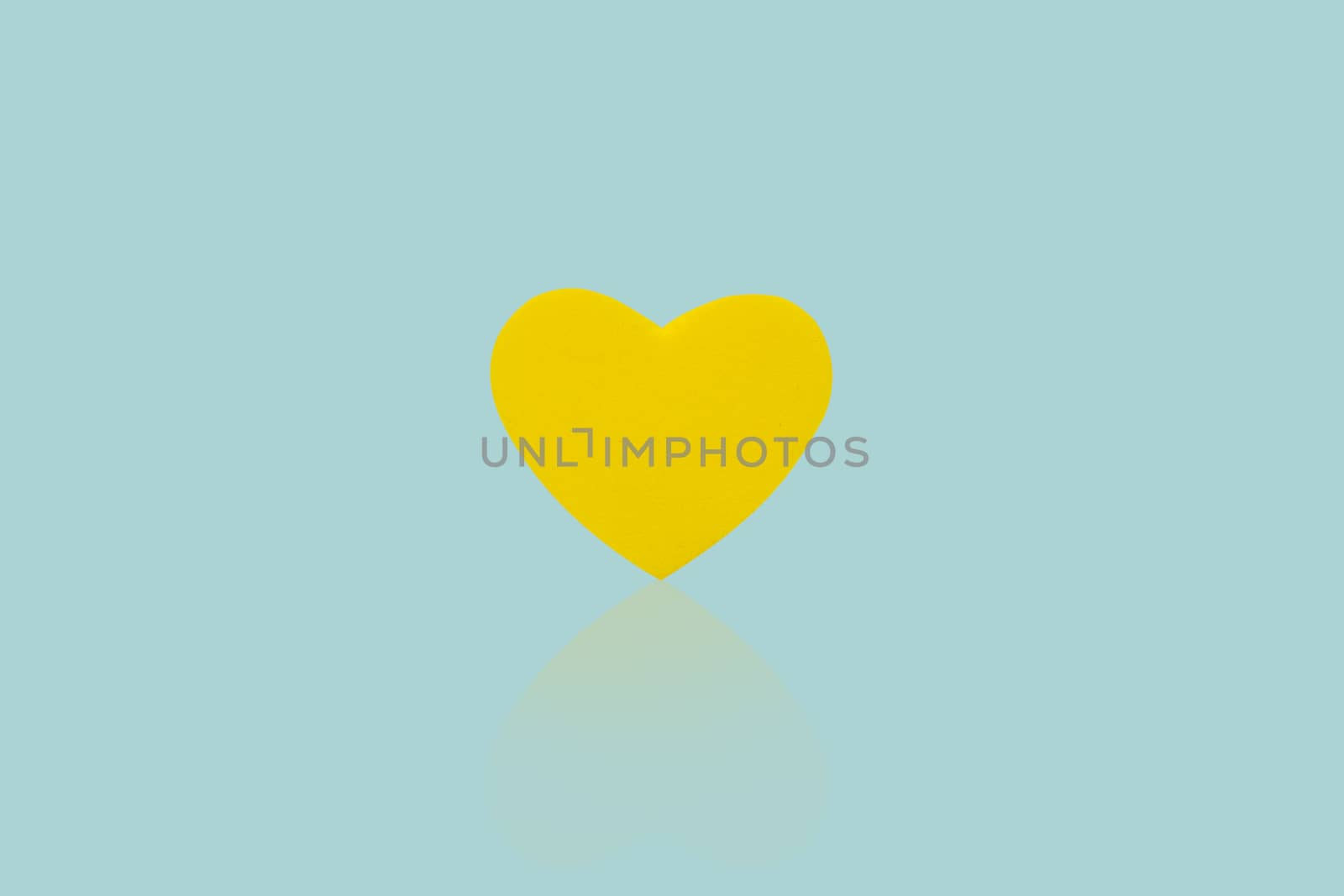 Yellow heart isolated on blue background.