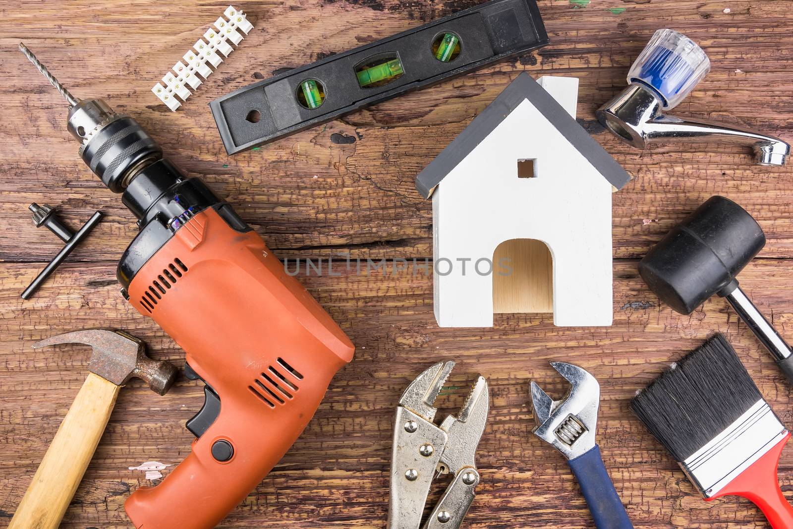 Wooden white house toy and construction tools on wooden background with copy space.Real estate concept, New house concept, Finance loan business concept, Repair maintenance concept