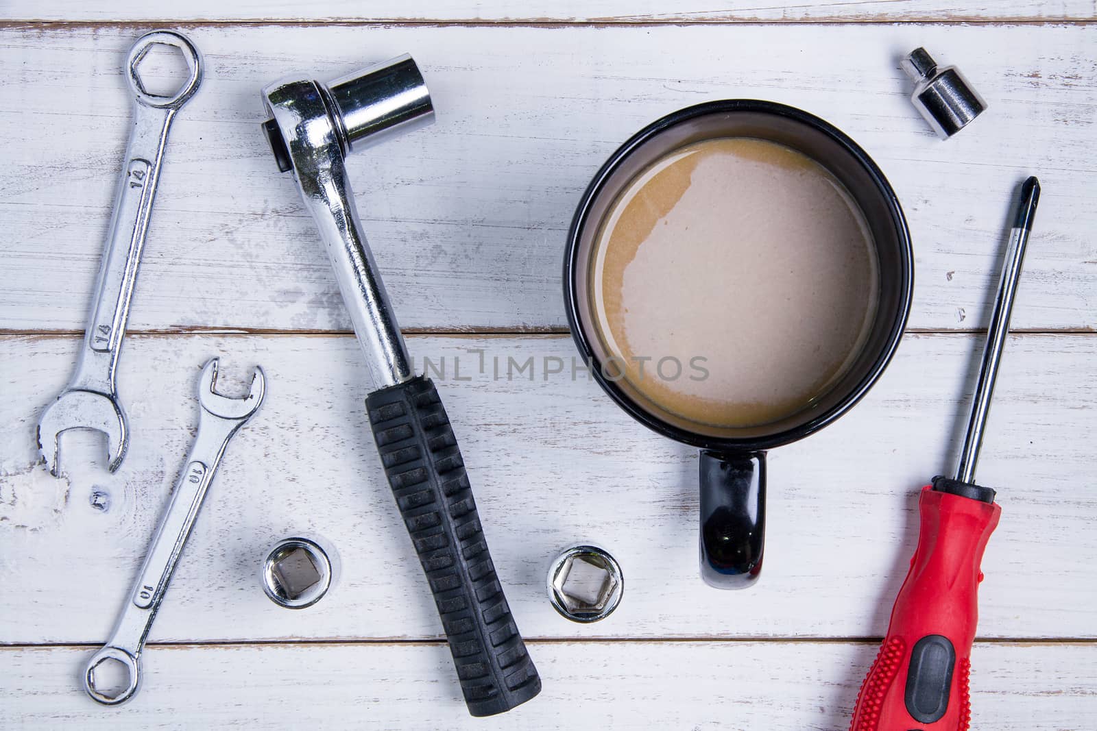 Coffee cup and equipment repair on the white wooden background.