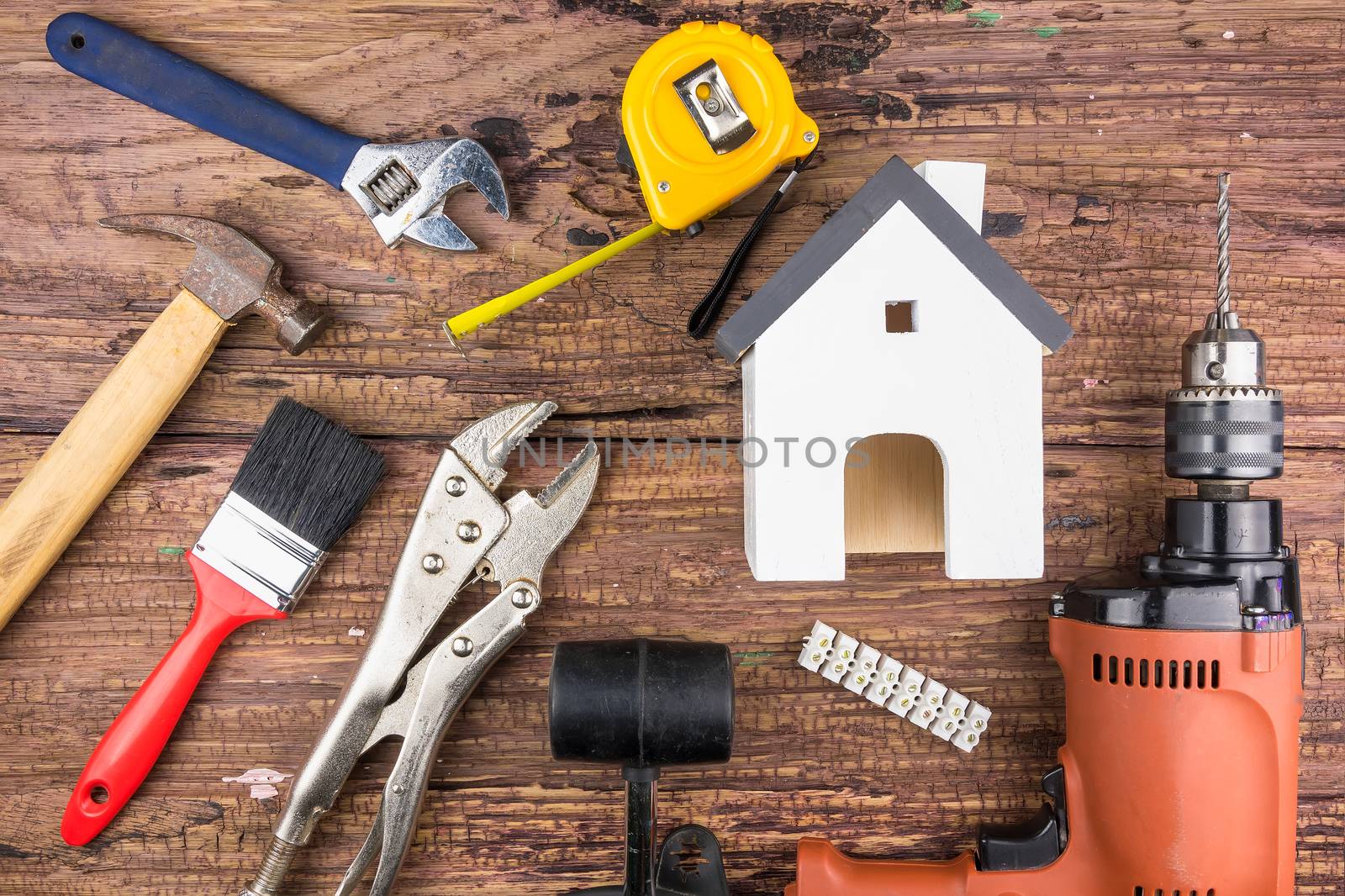 Wooden white house toy and construction tools on wooden background with copy space.Real estate concept, New house concept, Finance loan business concept, Repair maintenance concept