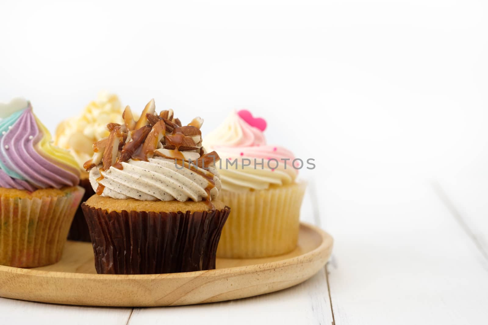 Cupcakes are beautifully decorated in clear lighting, AF point selection.