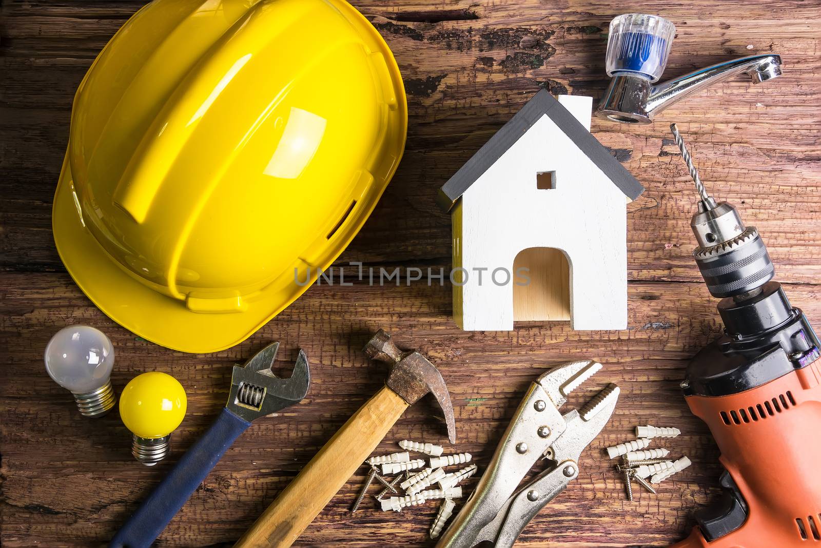 Wooden white house toy and construction tools on wooden background with copy space.Real estate concept, New house concept, Finance loan business concept, Repair maintenance concept
