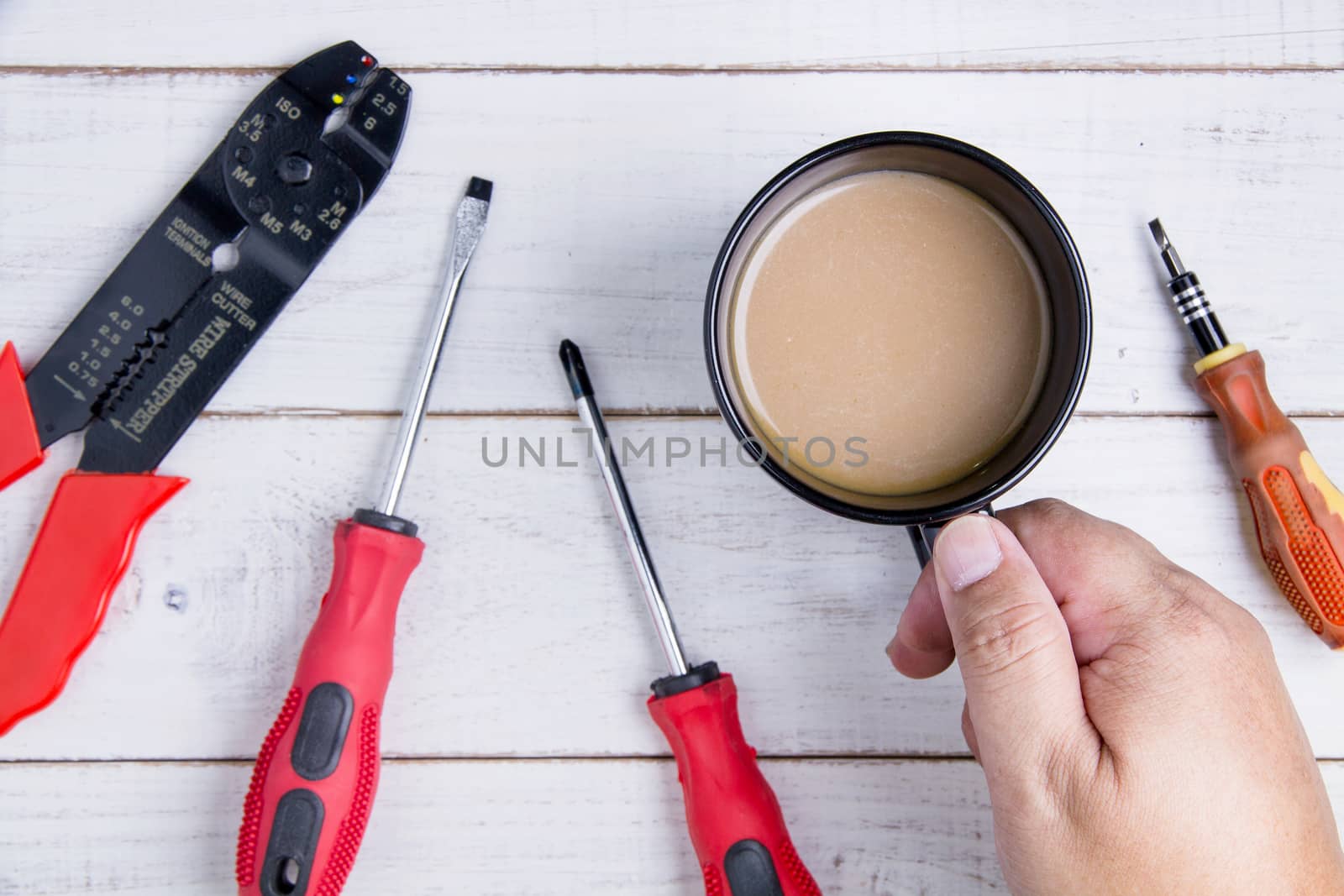 Coffee cup and equipment repair on the white wooden background.