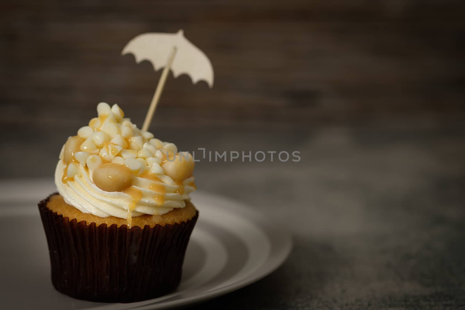 Cupcakes are beautifully decorated in Dark lighting, AF point selection.