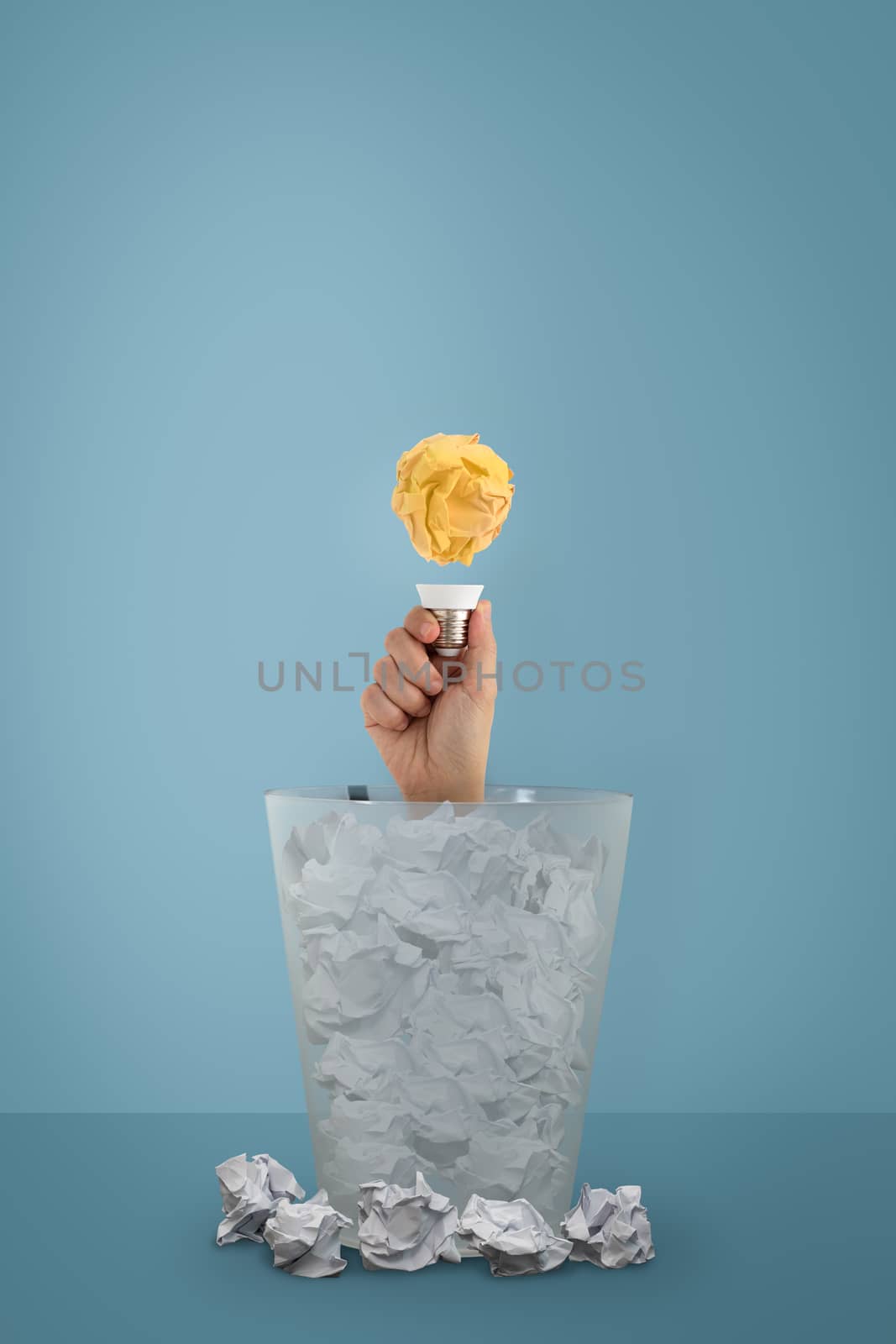 Idea with paper ball and lightbulb, The woman's hand appeared from the trash. Creative business concept.