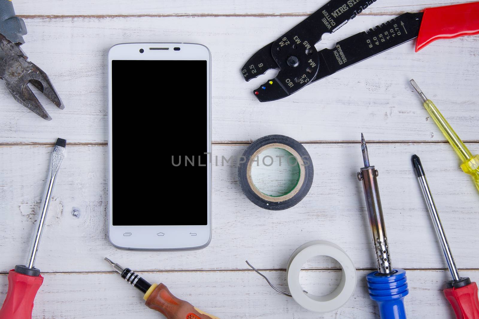 smartphone and equipment repair on the white wooden background