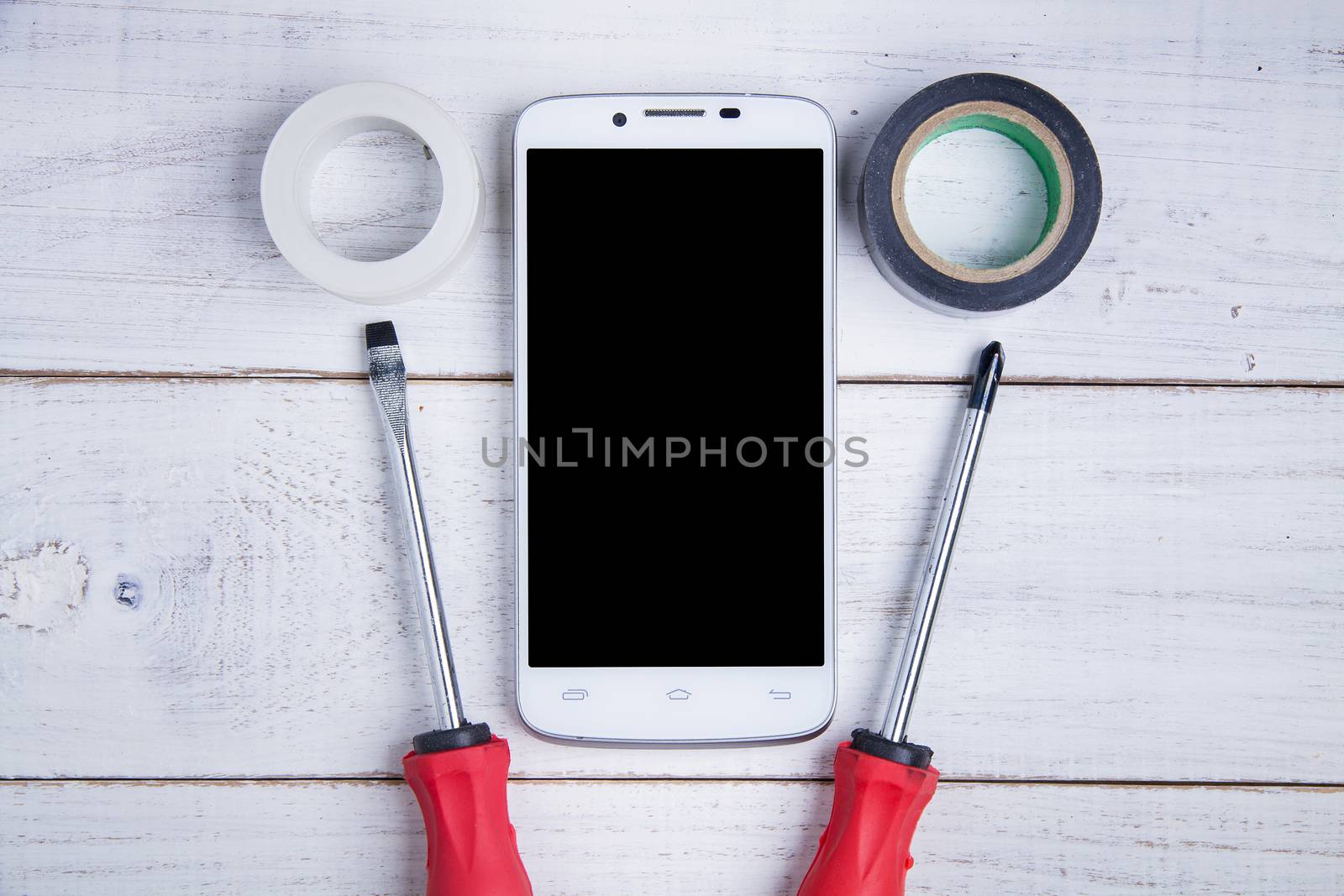 smartphone and equipment repair on the white wooden background. by Bubbers
