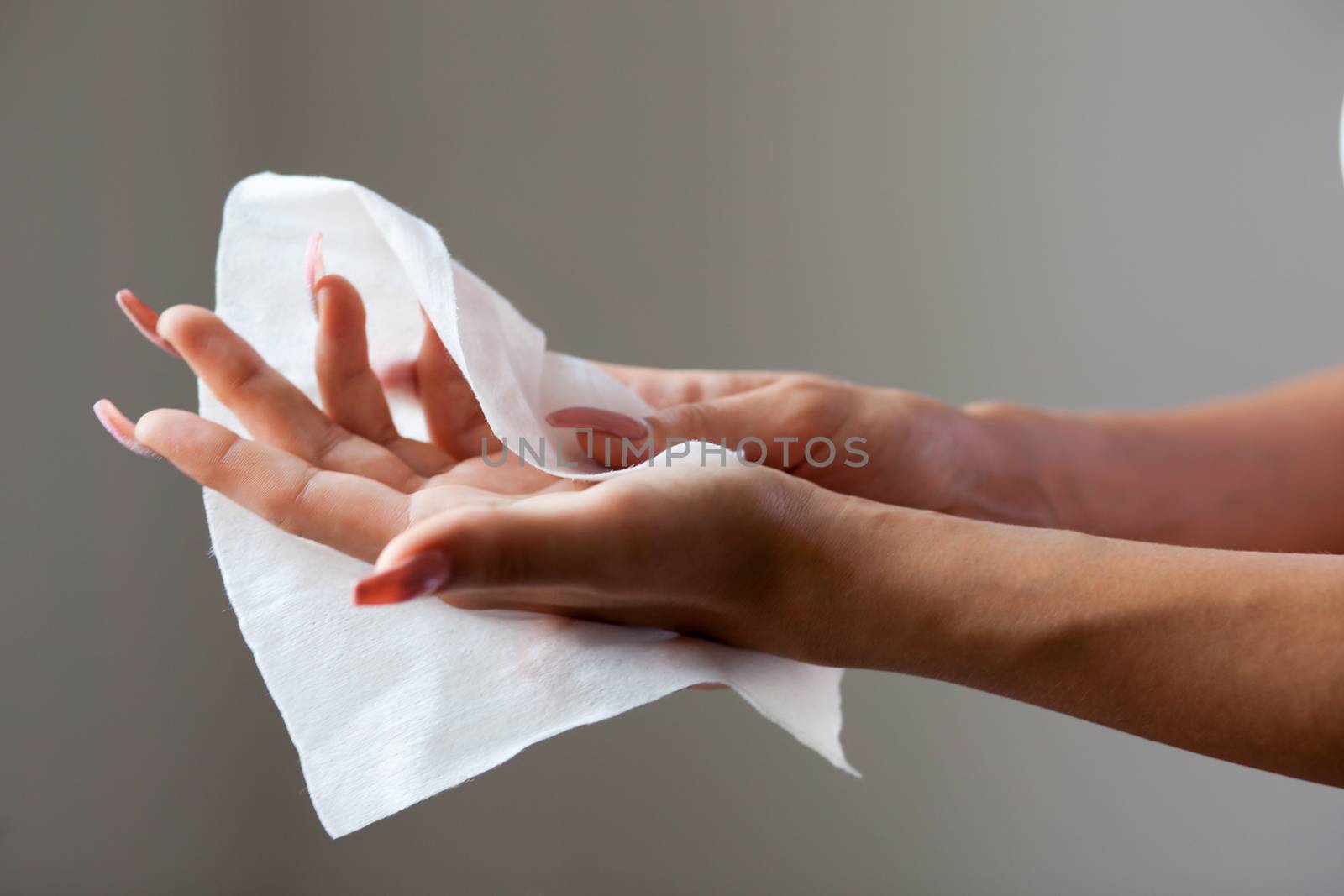 Young woman cleaning hands with wet wipes