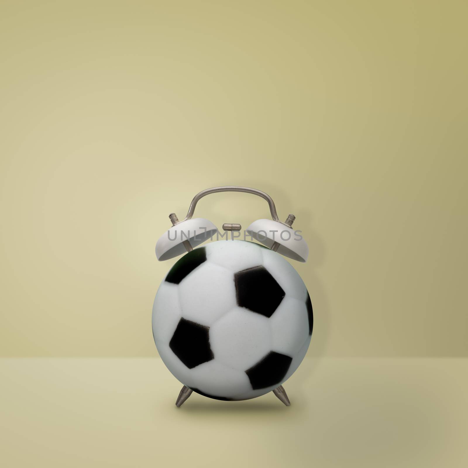 Football alarm clock on pastel yellow background, Creative idea minimal style, time concept.