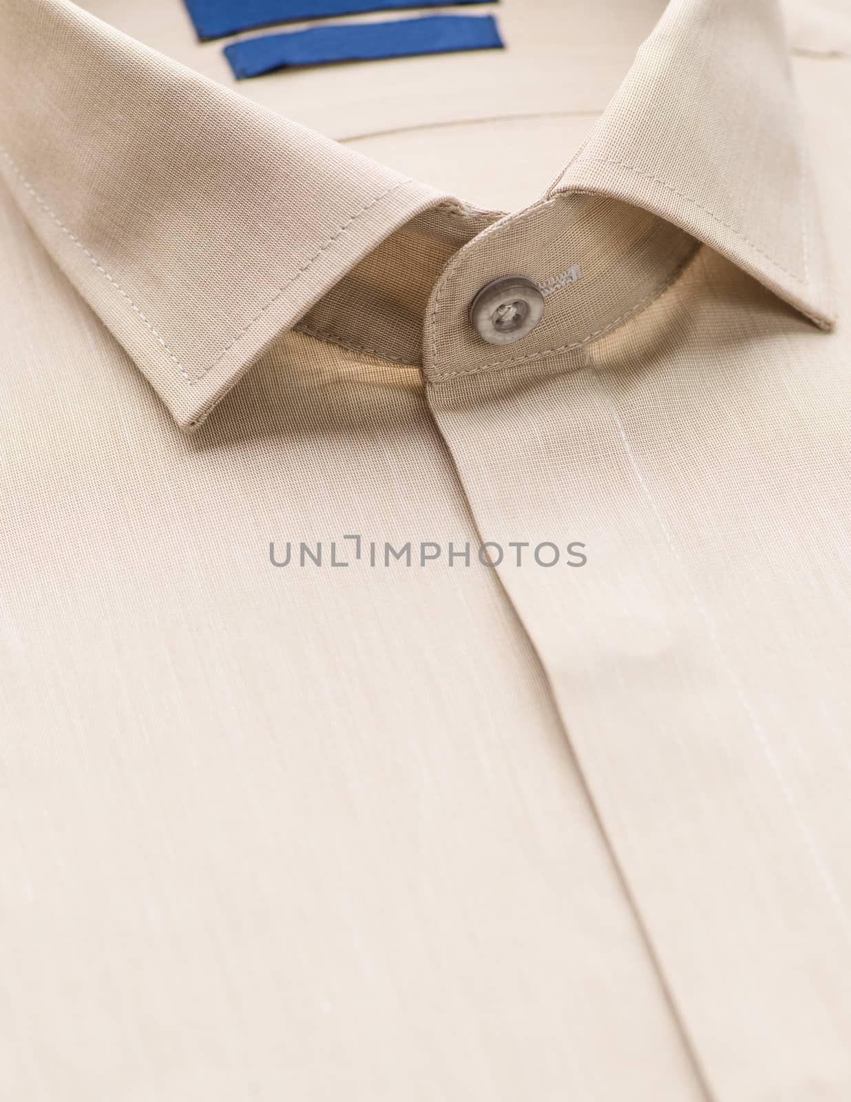 brown shirt with a focus on the collar and button, close-up