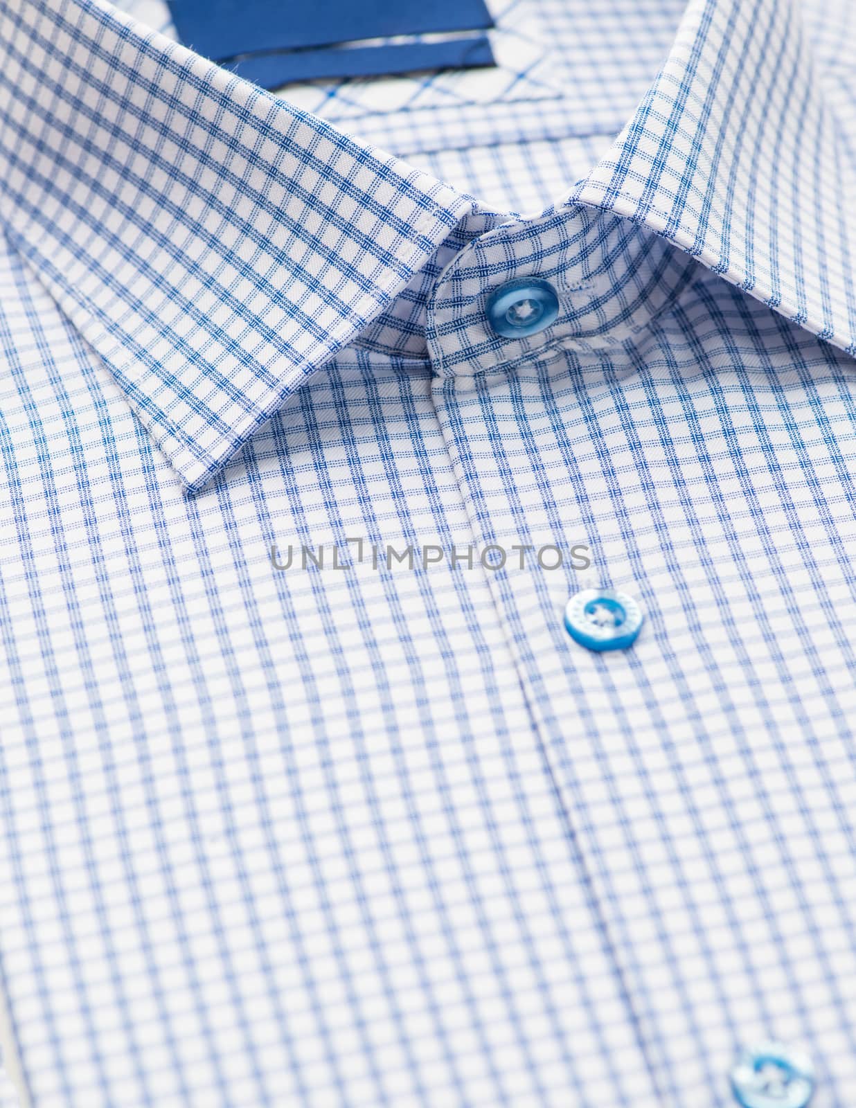 blue shirt with checkered pattern and with a focus on the collar and button, close-up