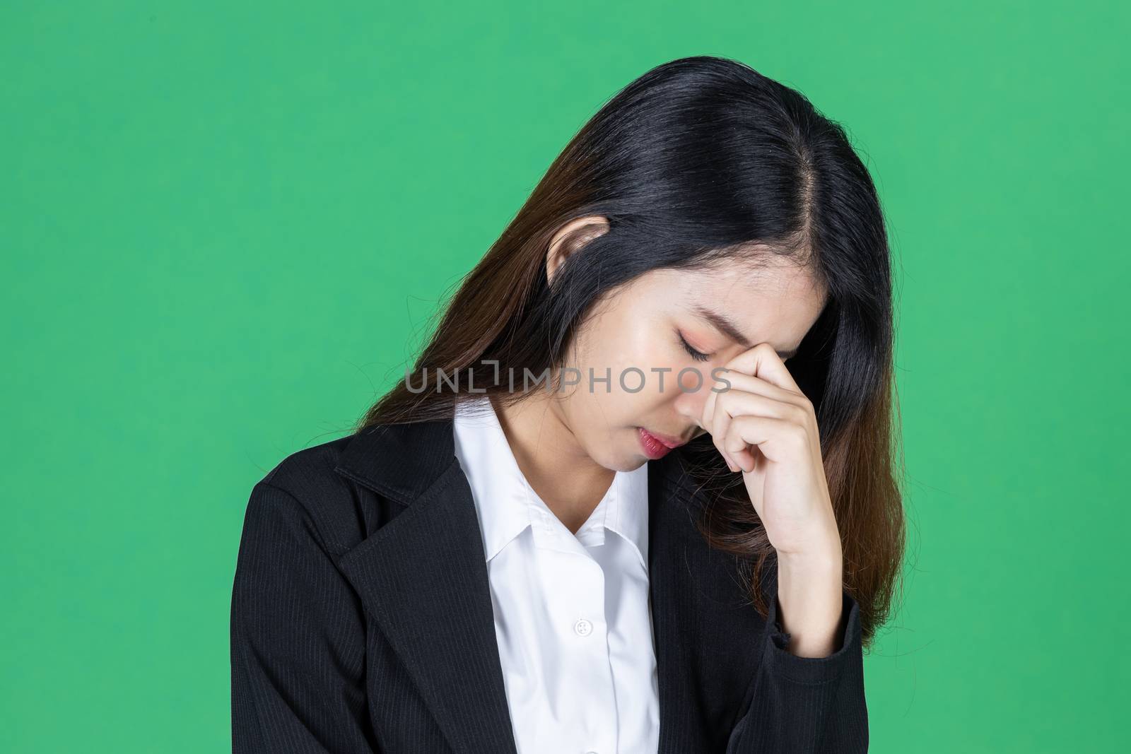 Frustrated stressed young Asian business woman with hands on face in depression on green isolated background. by tuaindeed