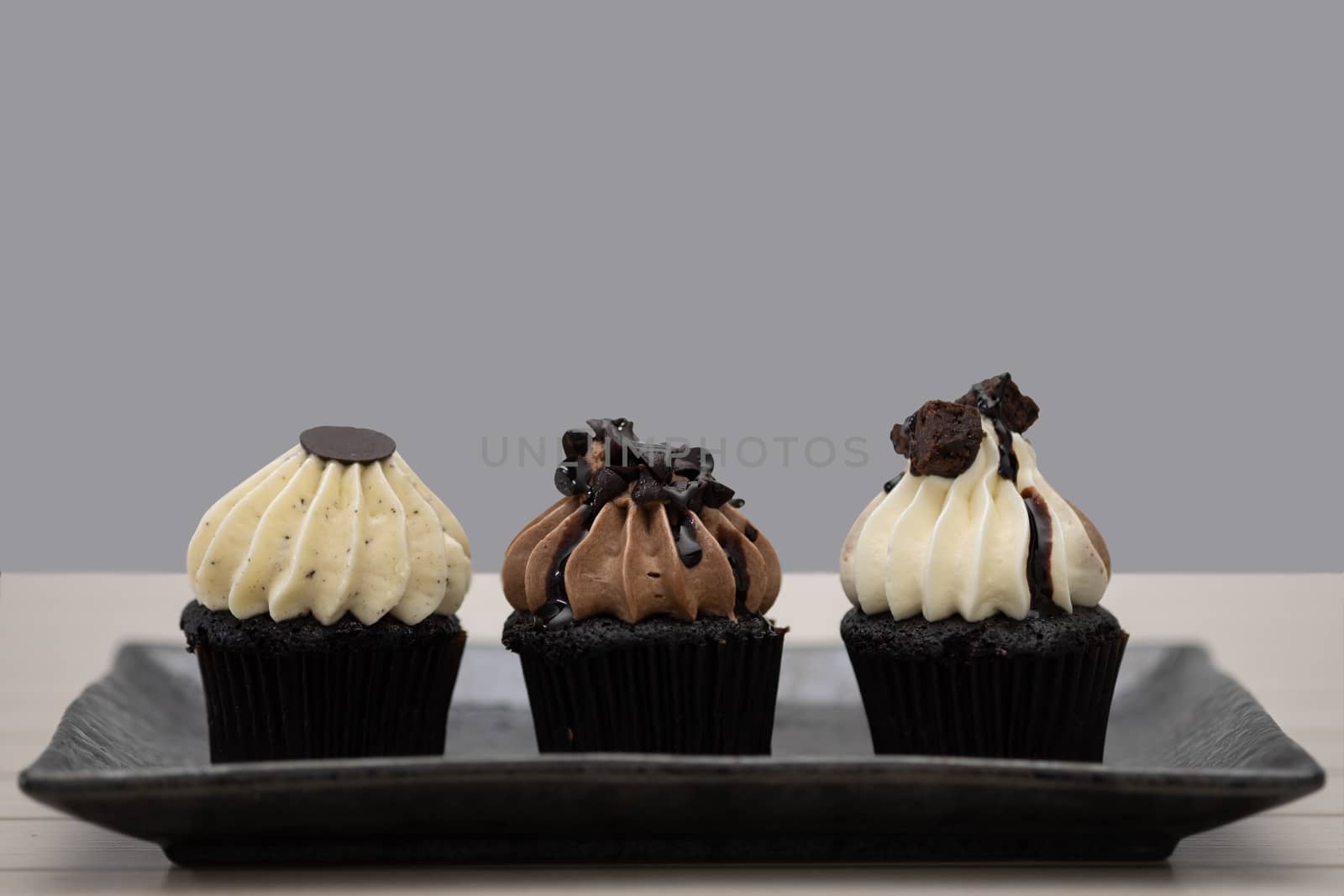Tasty chocolate mini cupcakes on a vintage background, sweet dessert.