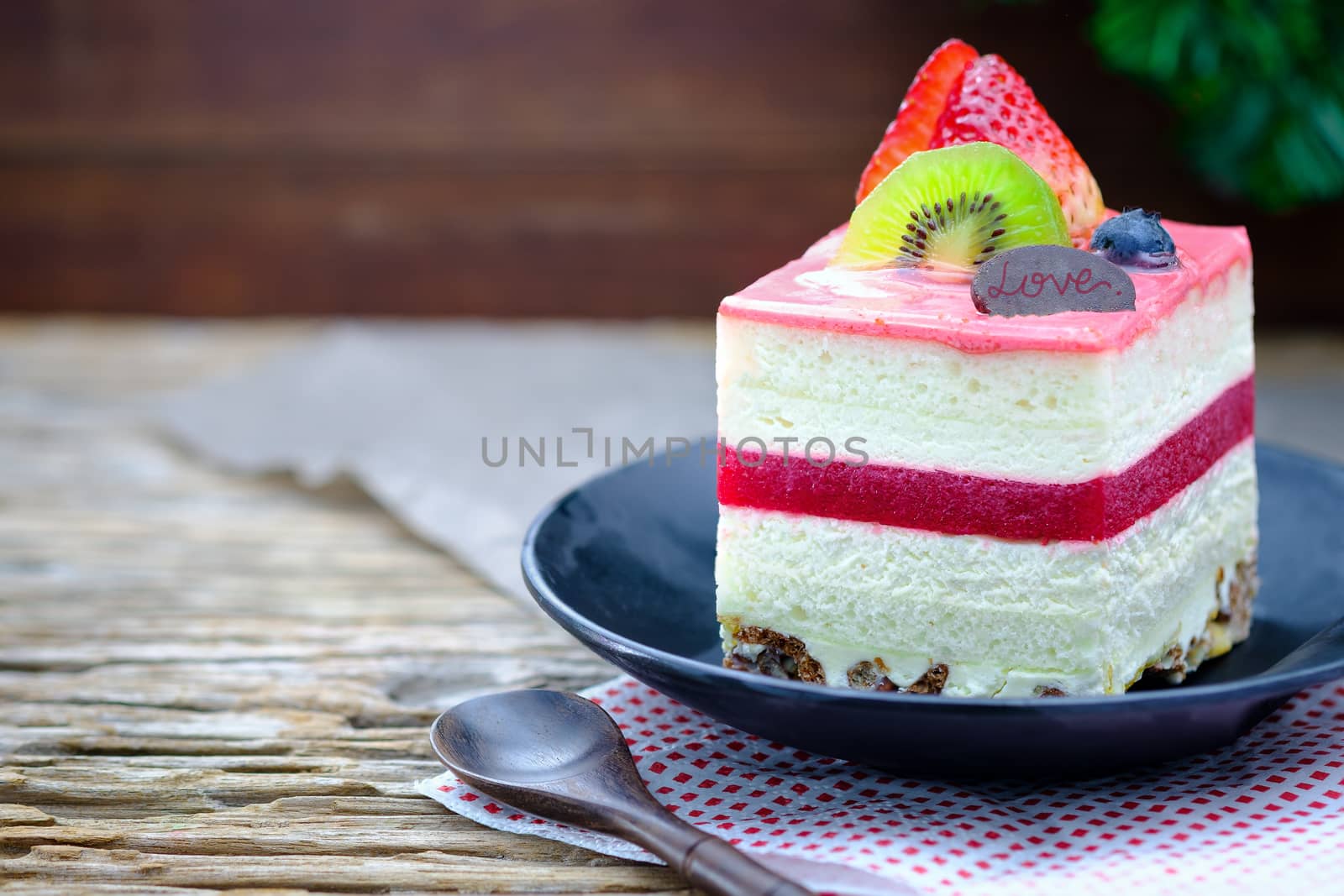 Fruit cake with  white cream on wooden table, close up, space to write.