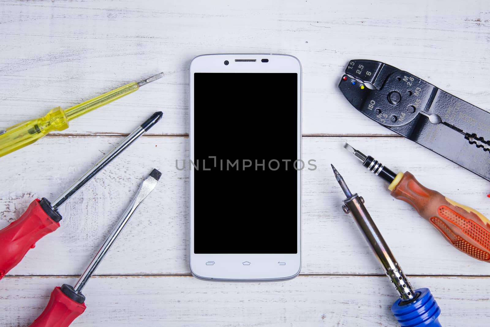 smartphone and equipment repair on the white wooden background