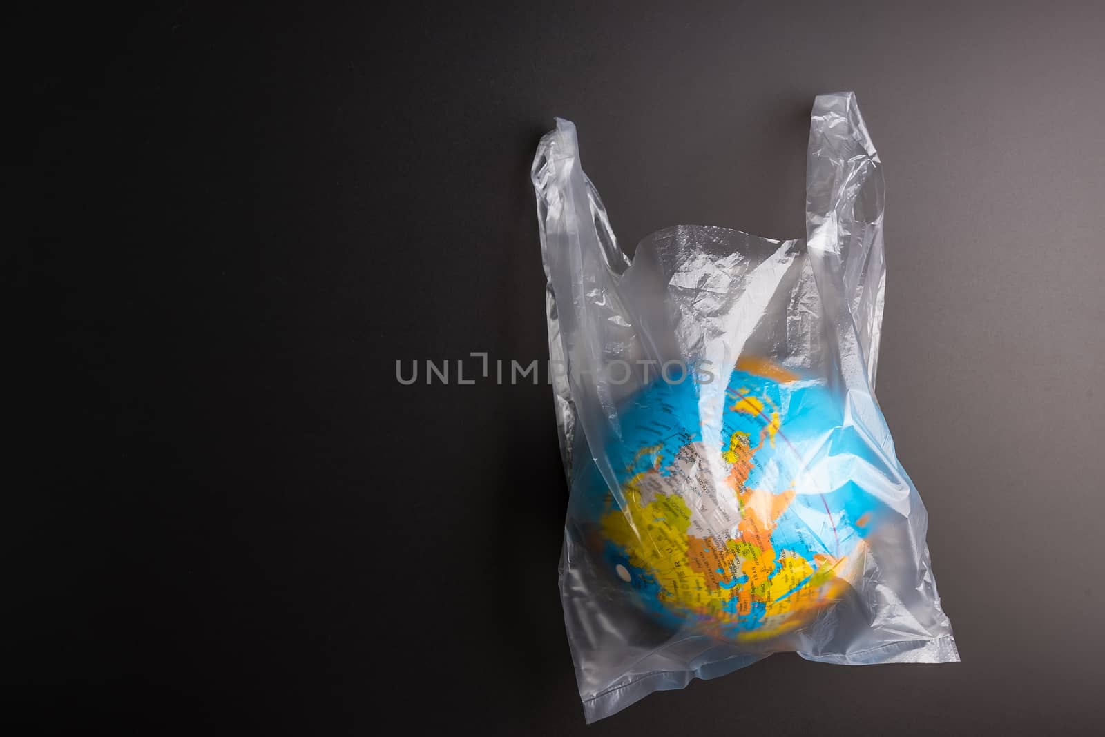 Plastic bag Earth world globe isolated on black background. Saving the planet Earth from plastic bags concept