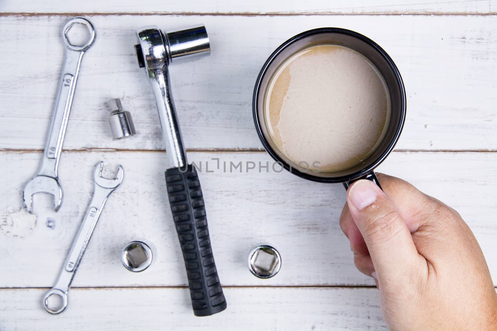 Coffee cup and equipment repair on the white wooden background.