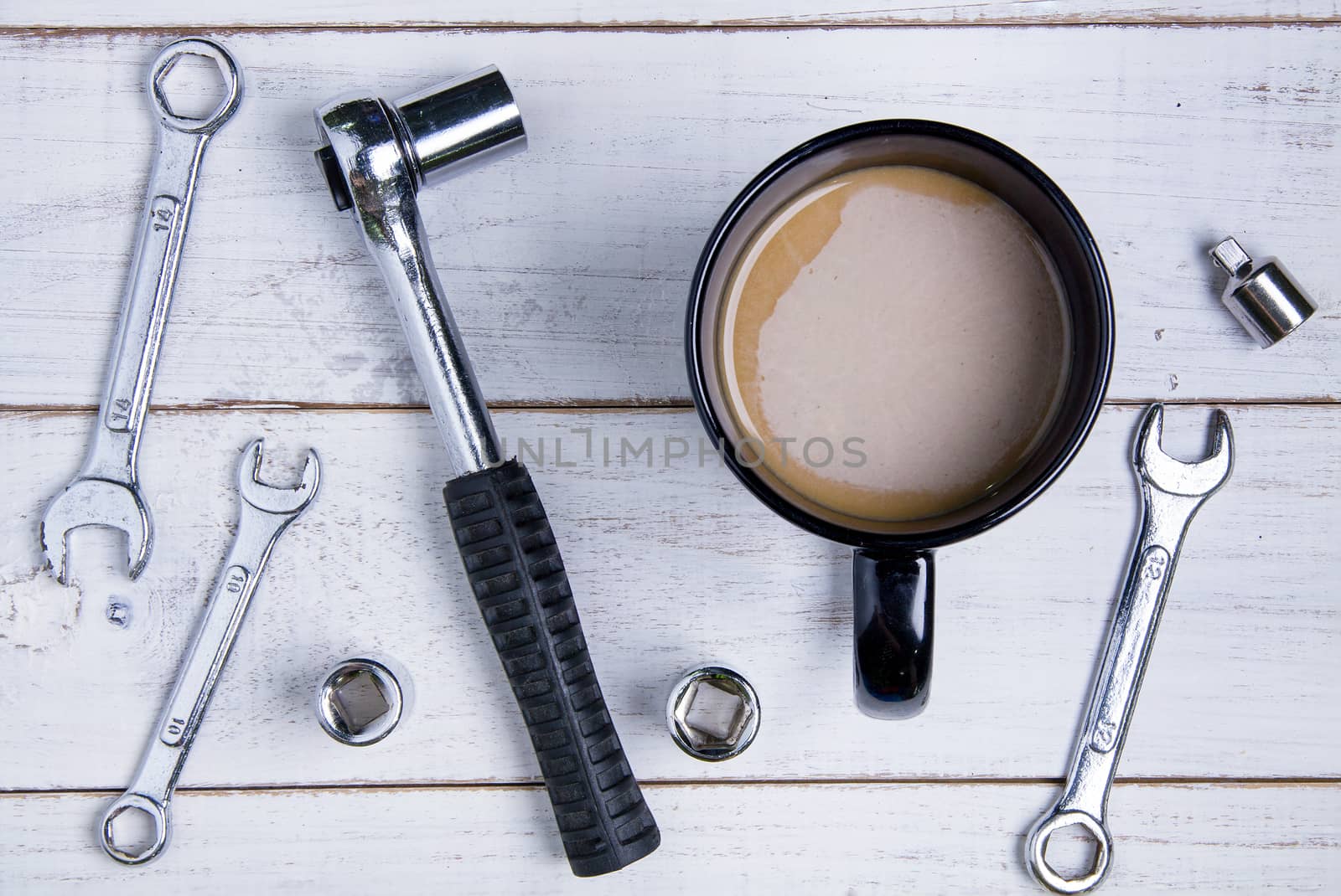 Coffee cup and equipment repair on the white wooden background.