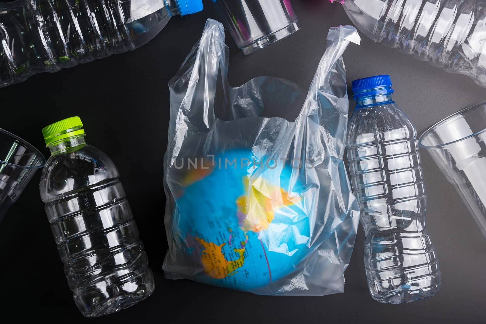 Earth world globe and plastic bottle waste on the black backgrou by Bubbers