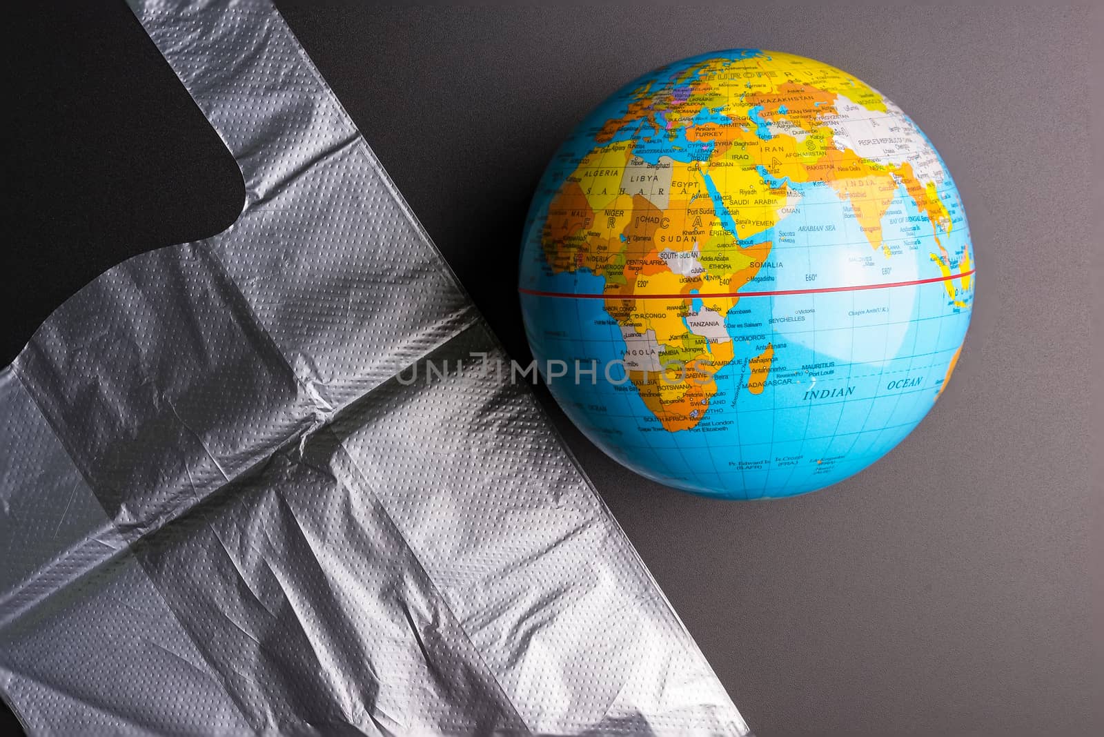 Plastic bag Earth world globe isolated on black background. Saving the planet Earth from plastic bags concept