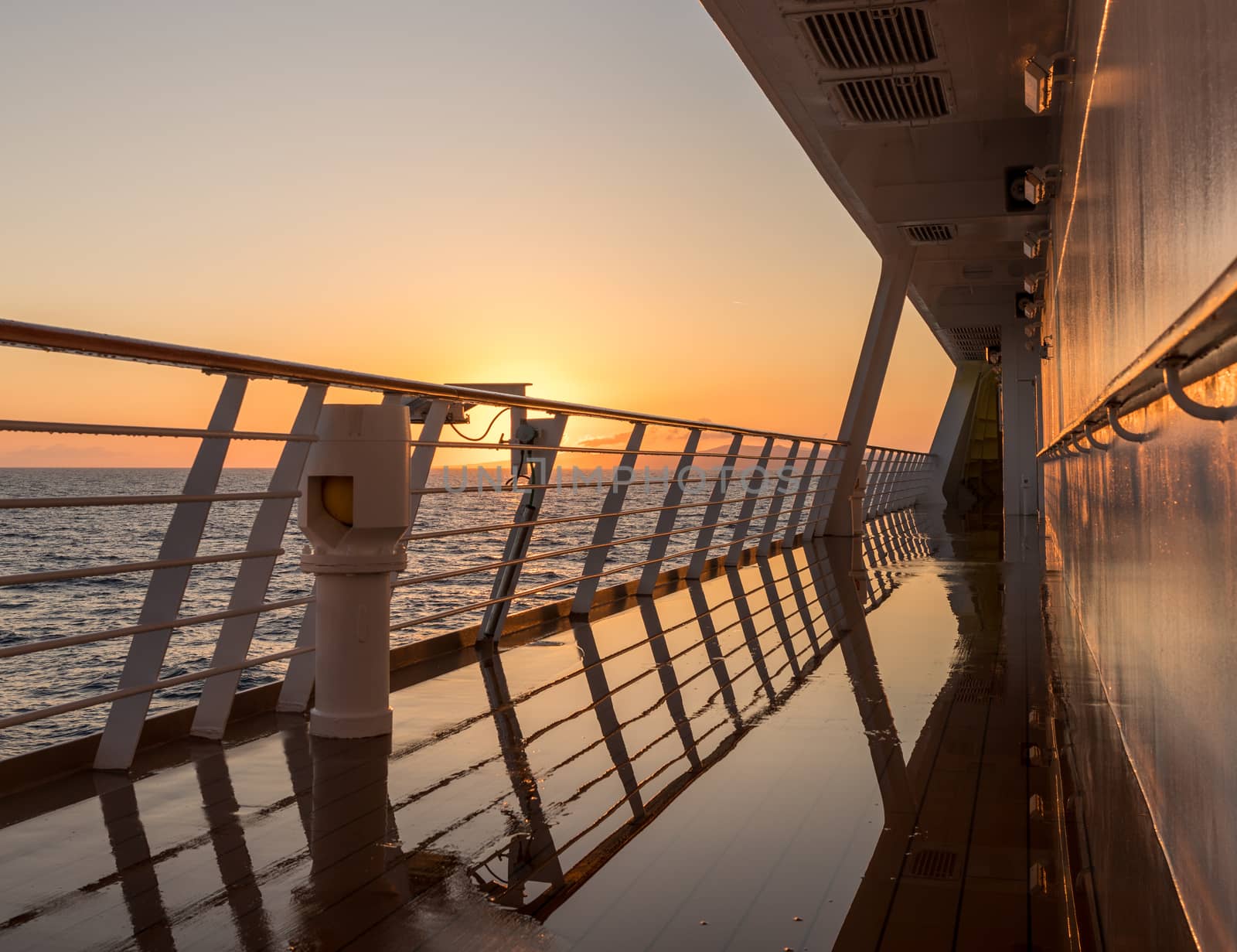 Deck on small cruise liner sailing across the ocean as the sun rises