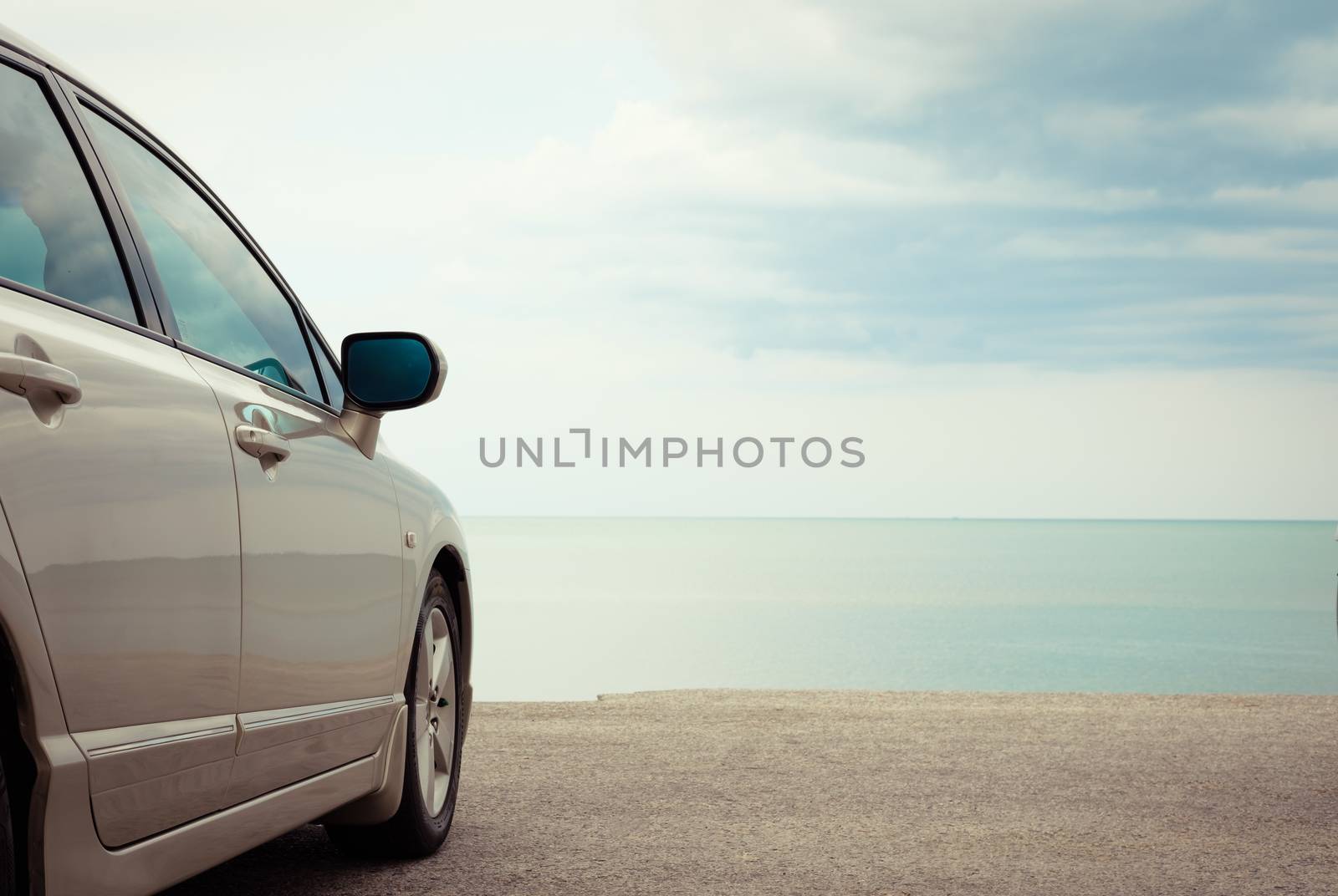 Golden car parked at the blue sea. Vintage picture.