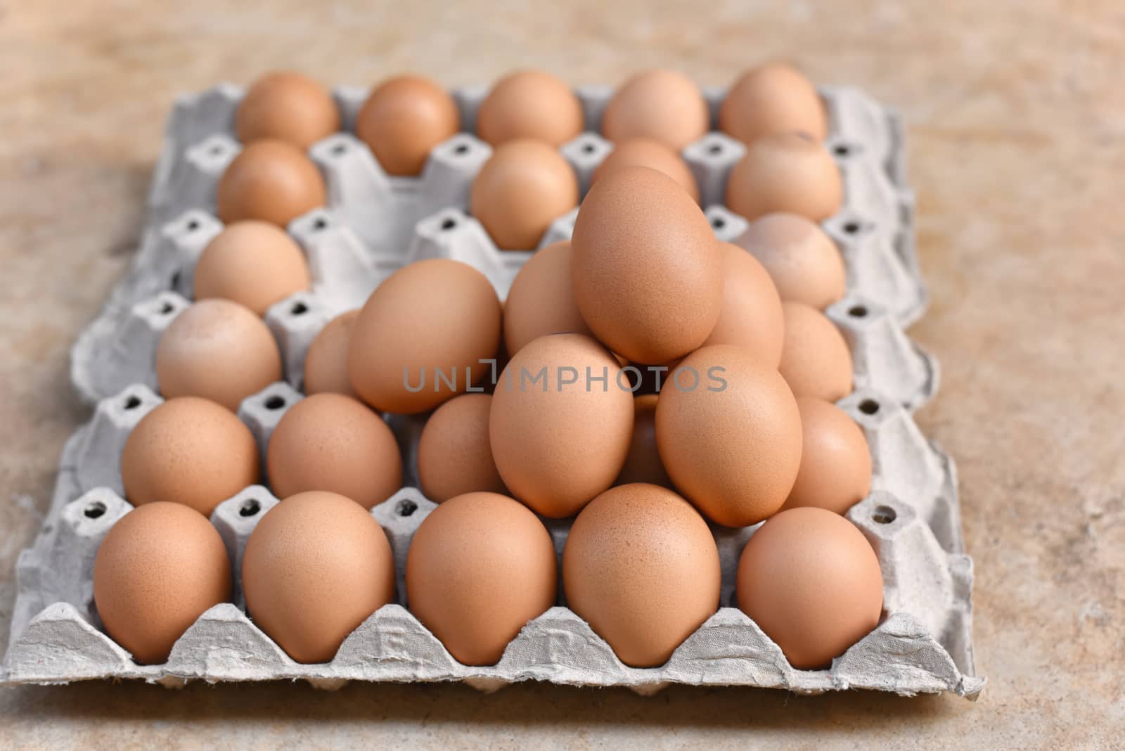 Egg, Chicken Egg. Close-up view of raw Brown chicken eggs in egg box on Cement floor background. Selected focus