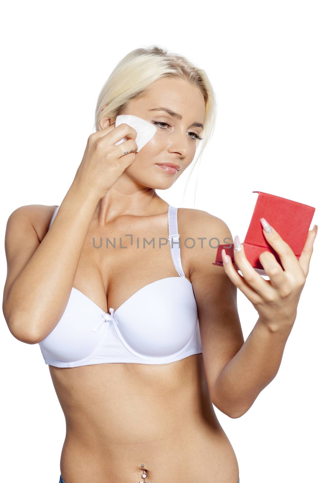 Young woman clean face and eyes with wet wipes, holding mirror, remove make-up, body breast lingerie