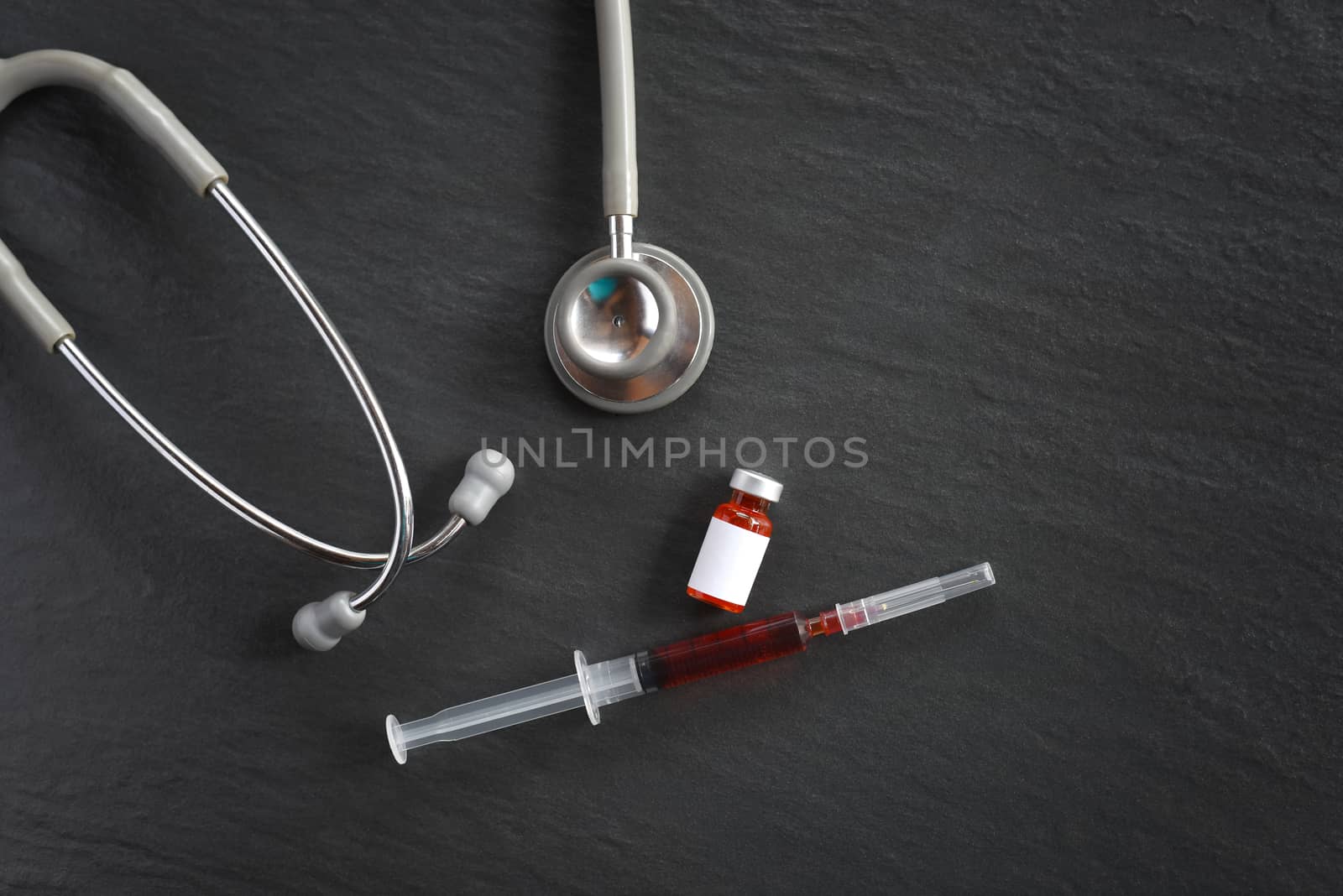 stethoscope and Vaccine and syringe injection on black background. Covid-19 or Coronavirus Concept for prevention,immunization and treatment from corona virus infection. Medicine infectious concept.