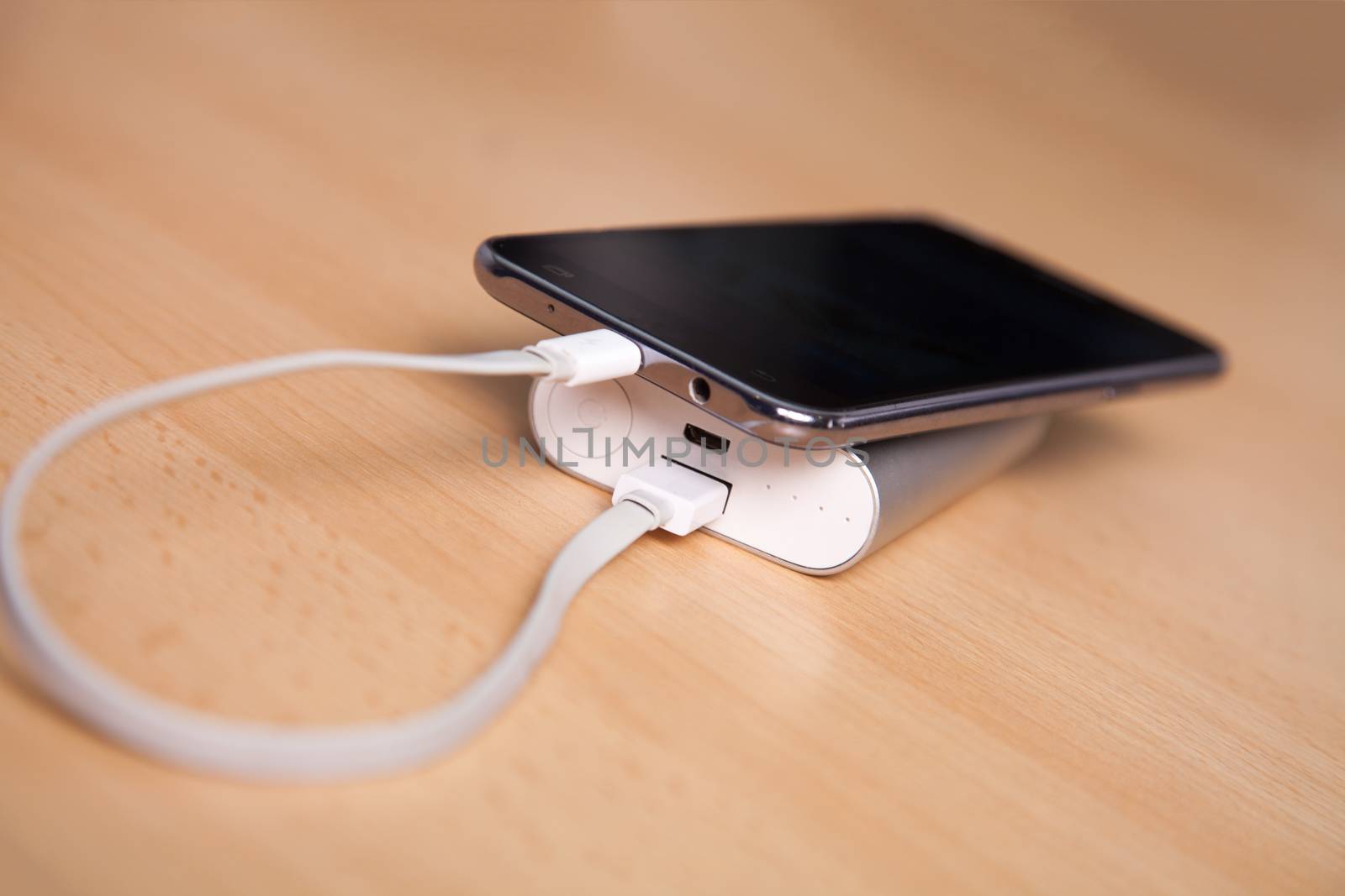 Mobile Phone Charging With Power Bank on wooden table