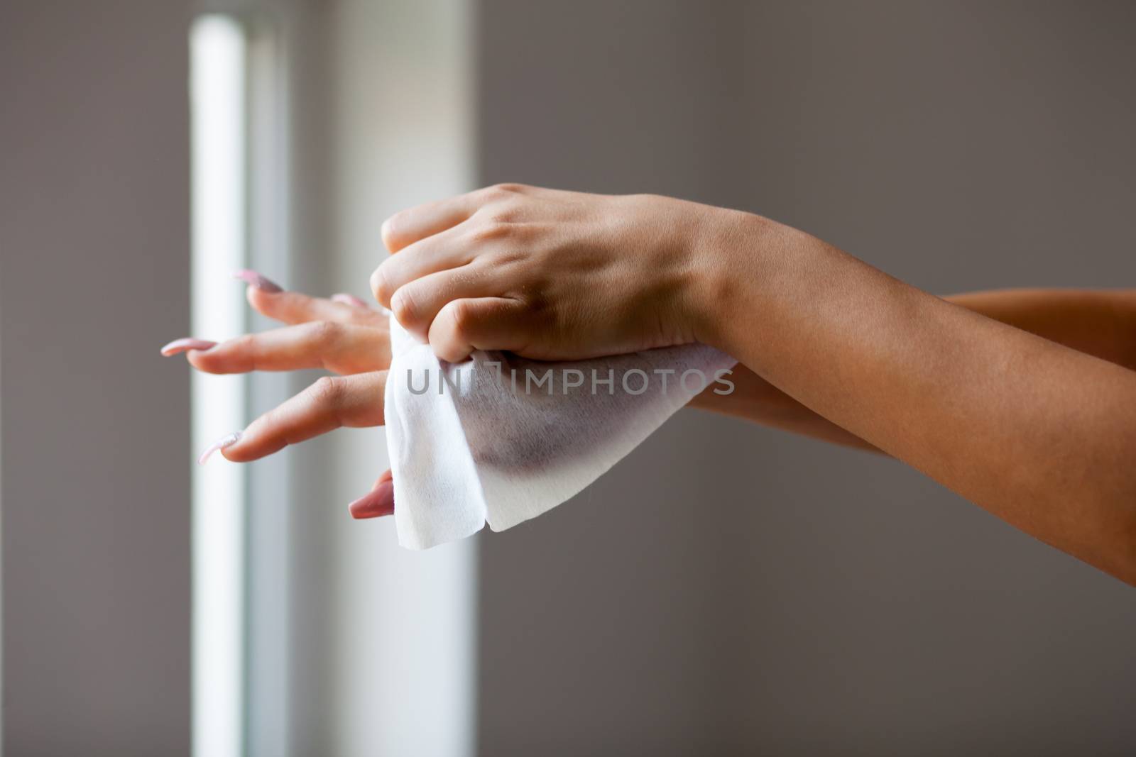 Young woman clean hands with wet wipes