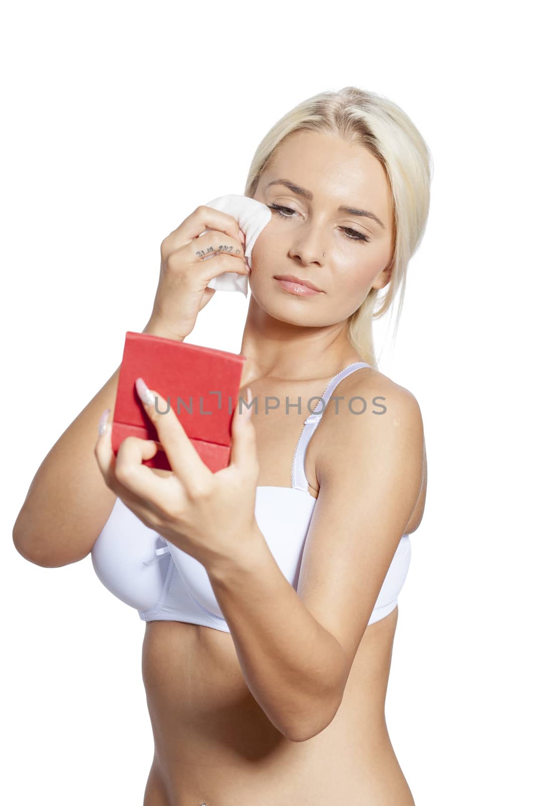 Young woman clean face and eyes with wet wipes, holding mirror, remove make-up, body breast lingerie