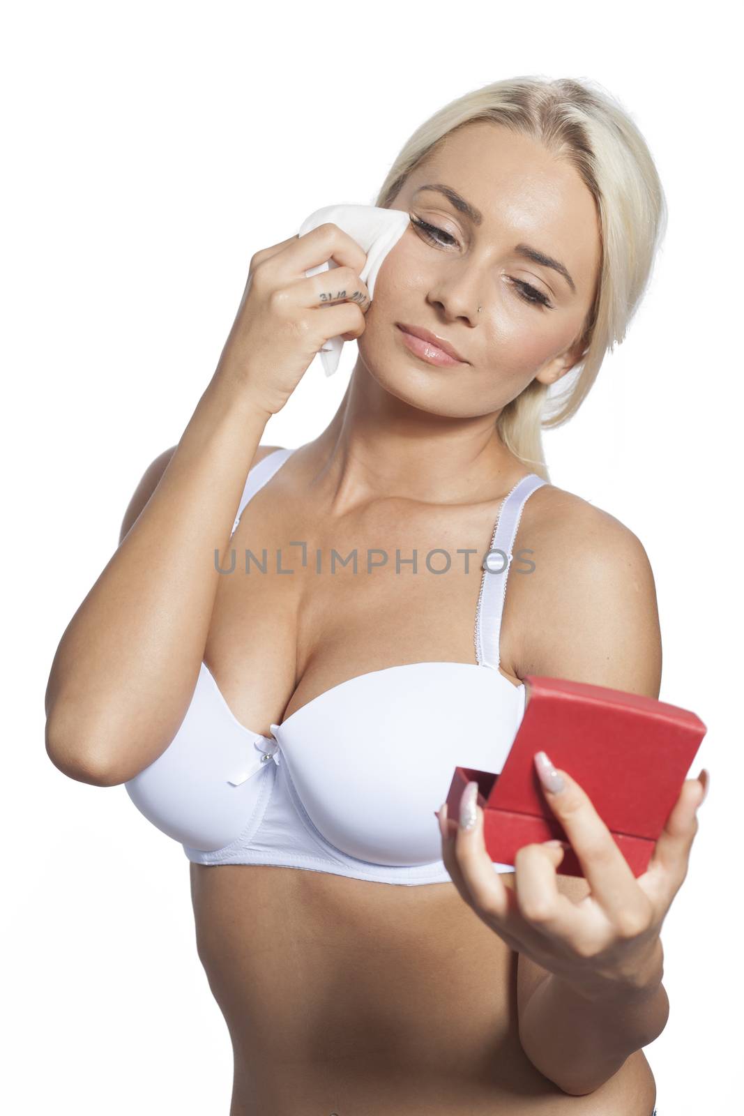 Young woman clean face with wet wipes and holding mirror by adamr