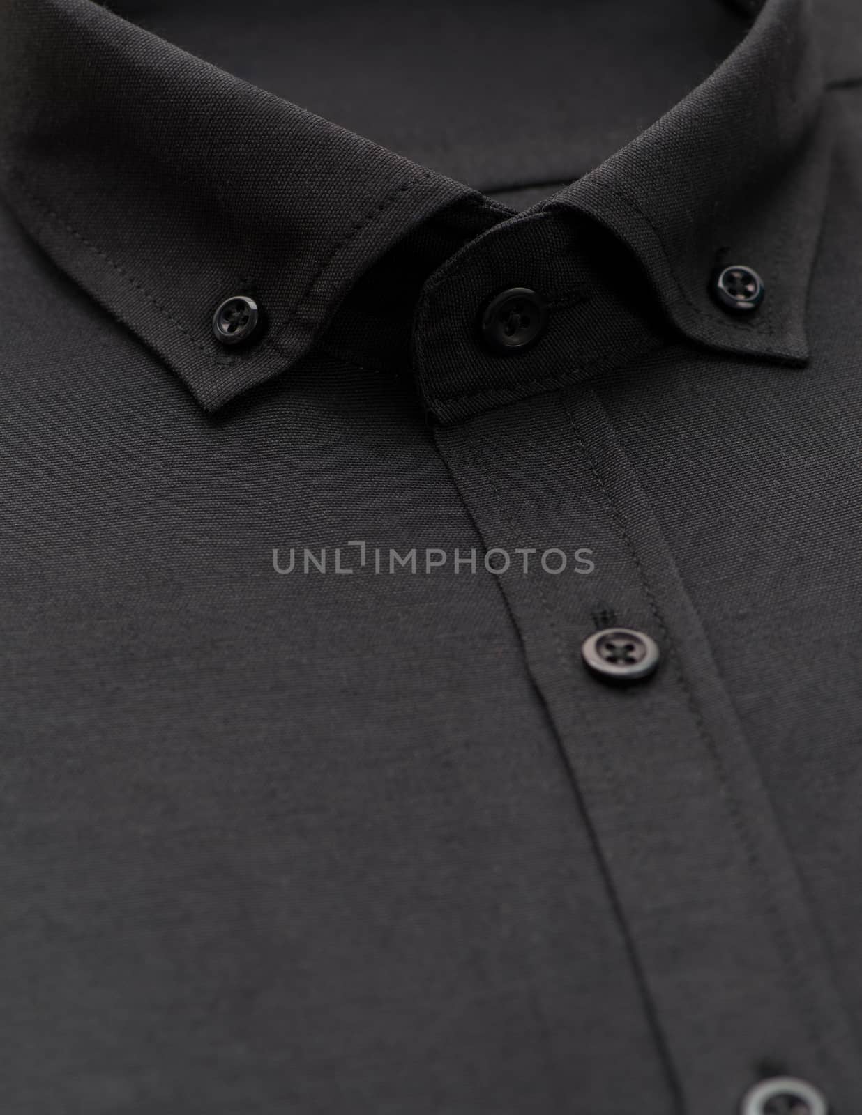 black shirt with a focus on the collar and button, close-up