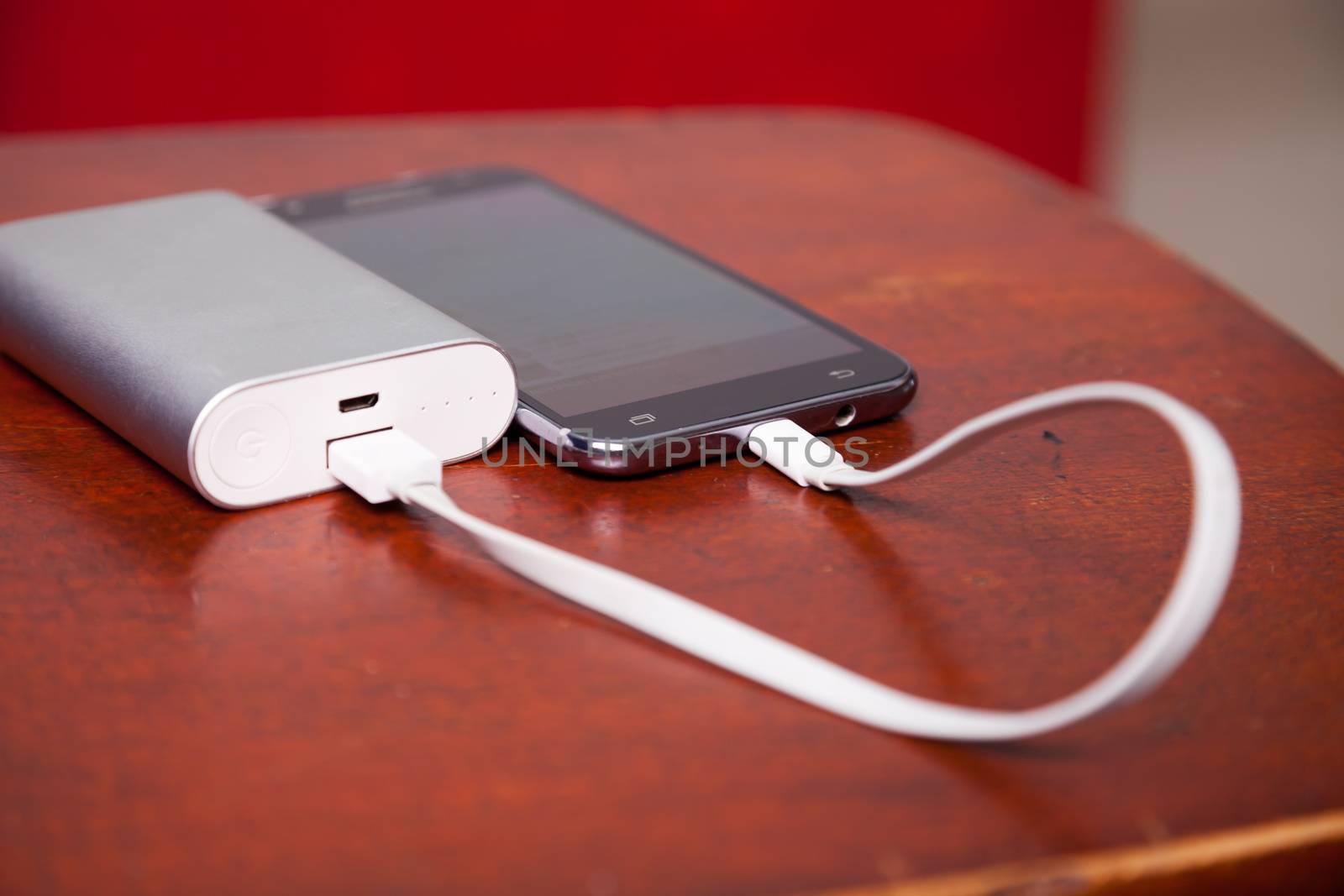 Mobile Phone Charging With Power Bank on wooden table