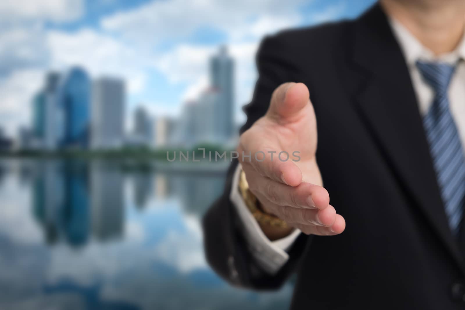 Businessmen show hand for shake hands on building  background with copy space.