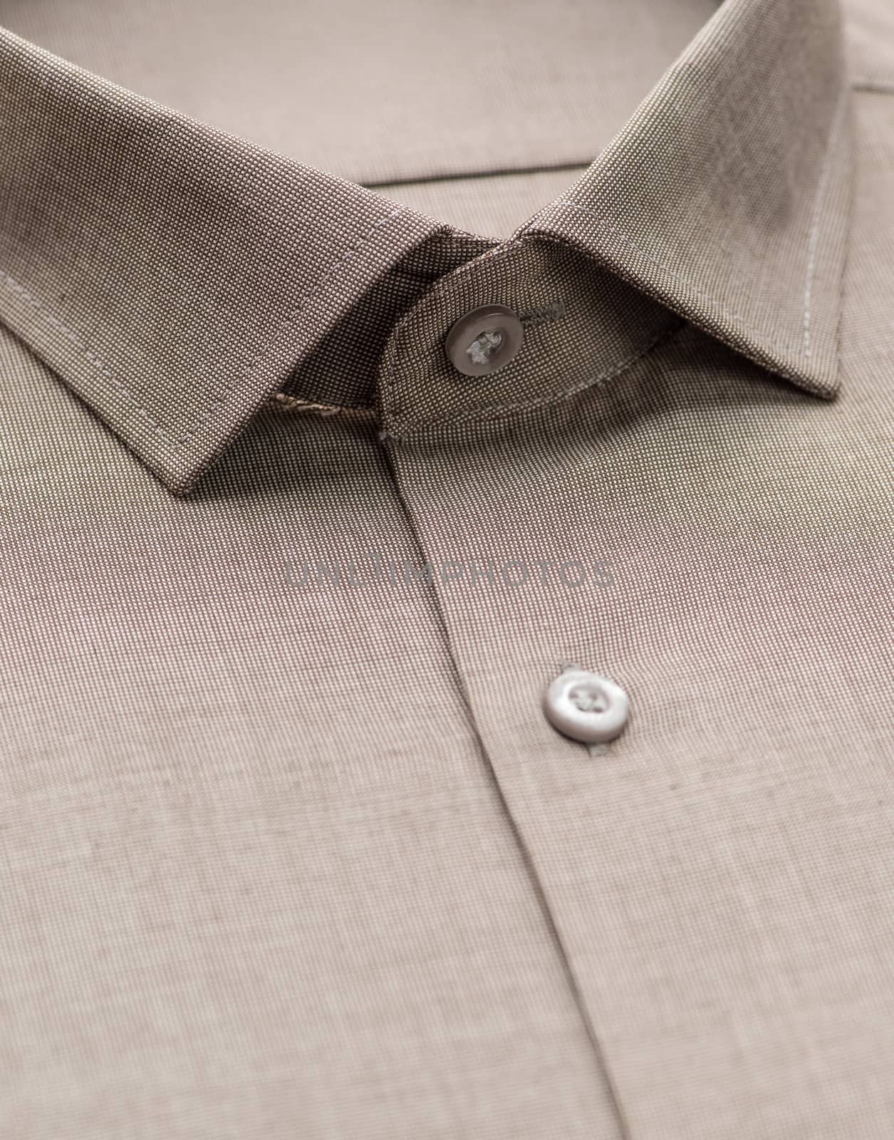 brown shirt with focus on collar and button, close-up