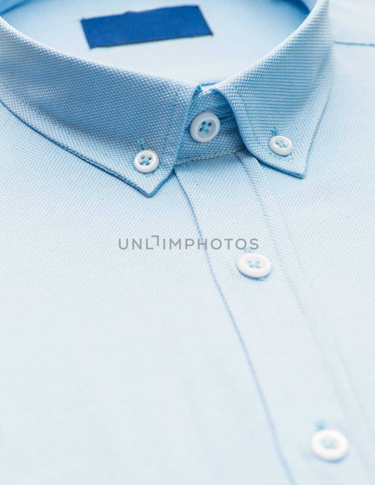 blue shirt with focus on collar and button, close-up