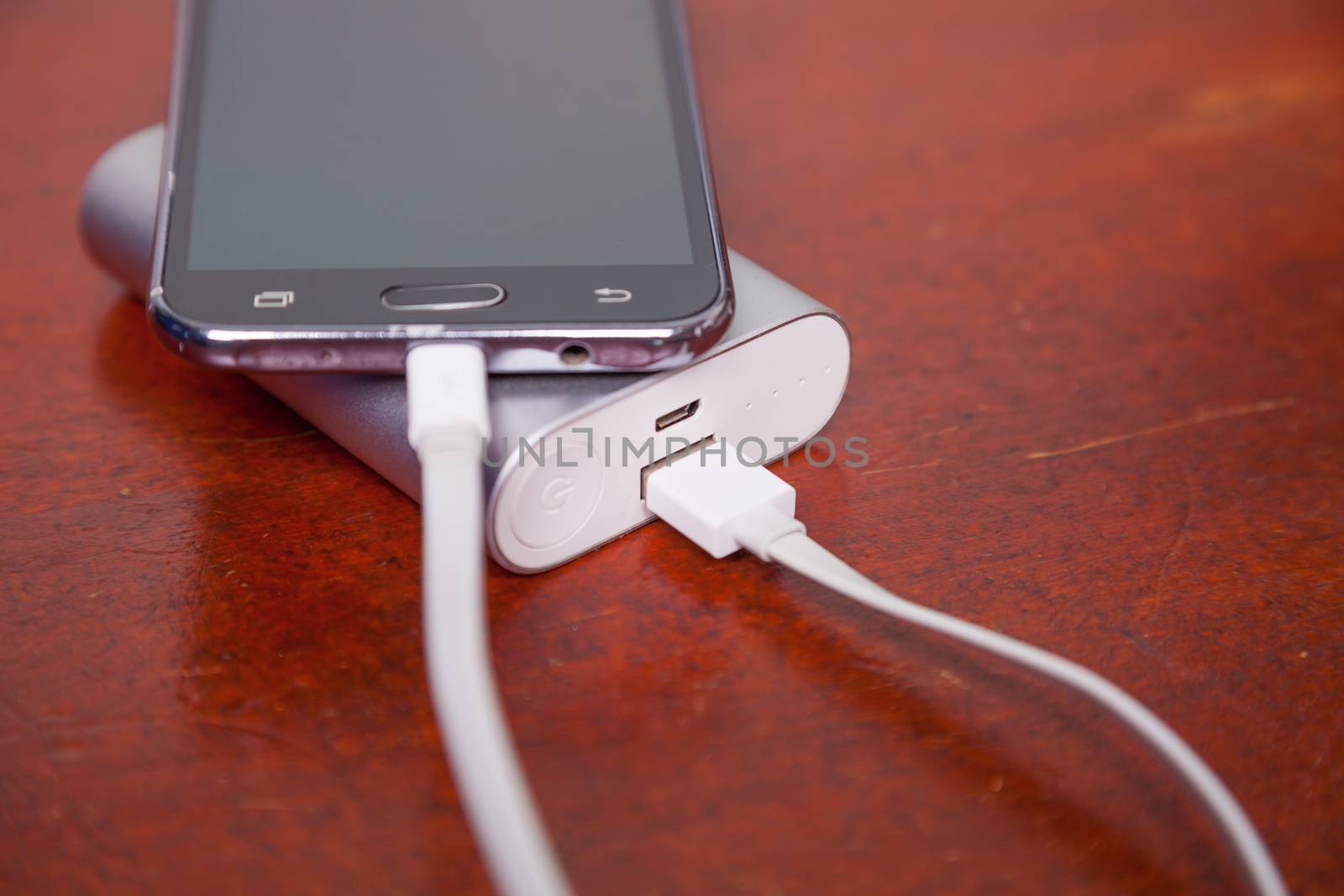 Mobile Call Phone Charging With Power Bank on wooden table