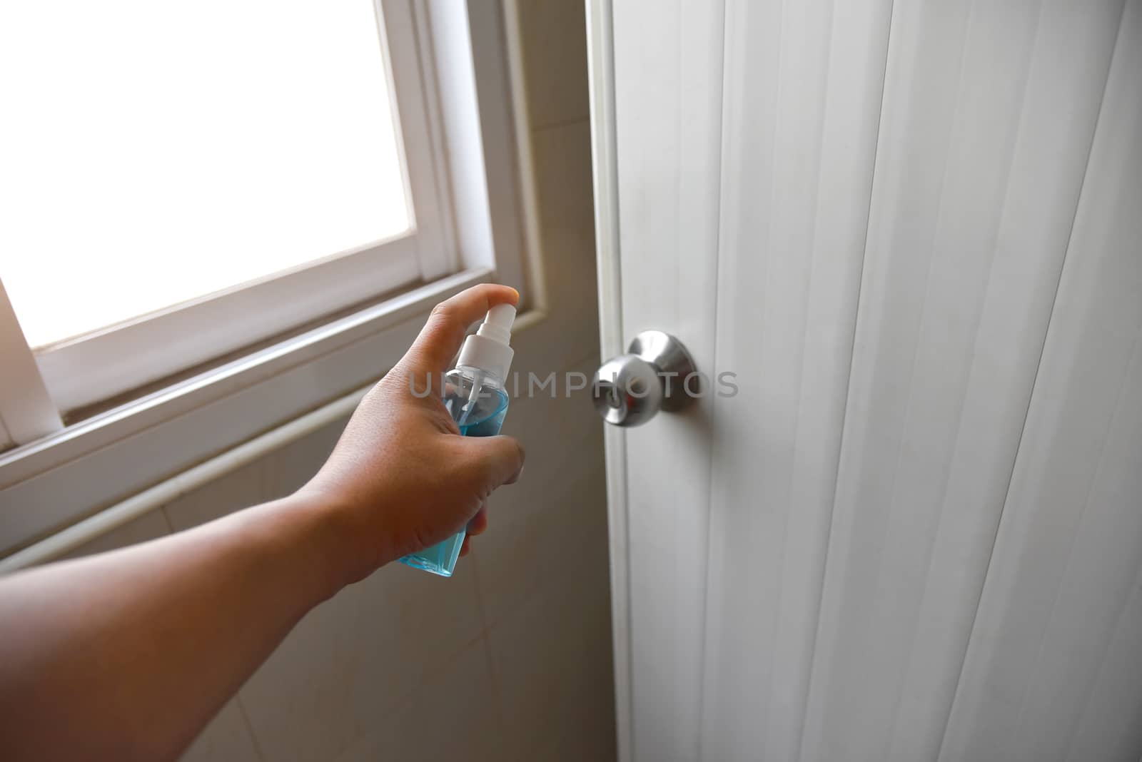 Hand-held alcohol spray, tearing the door knob to kill germs or the virus, Kovid-19. concept Cleaning and protect colona virus or Infection prevention covid 19. Selected focus