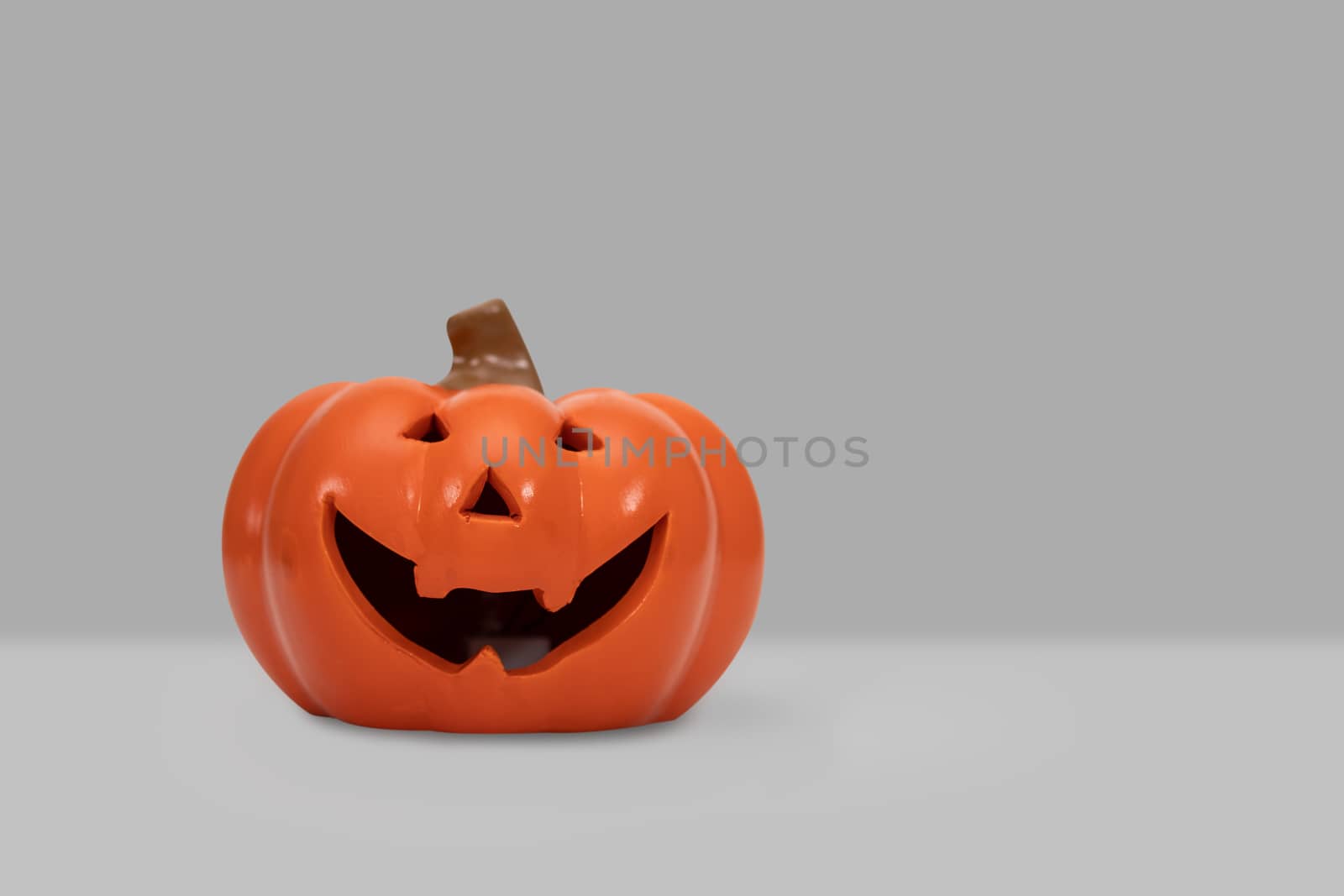 Halloween pumpkin on grey background by feelartfeelant