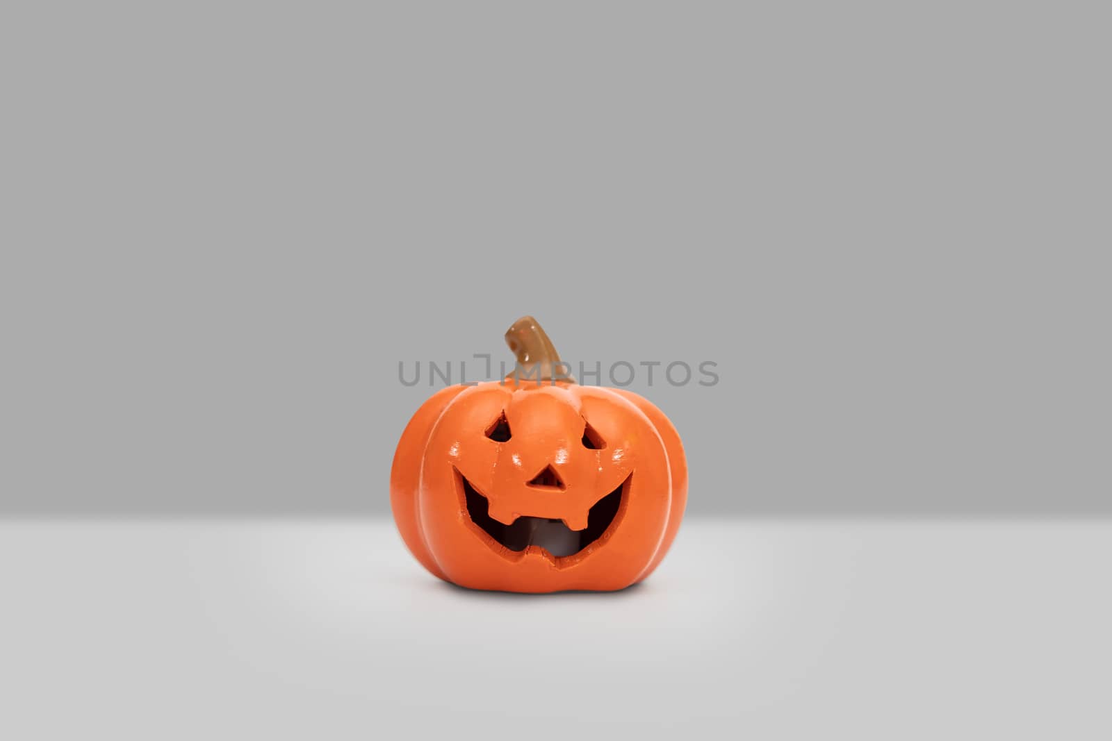 Halloween pumpkin on grey background by feelartfeelant